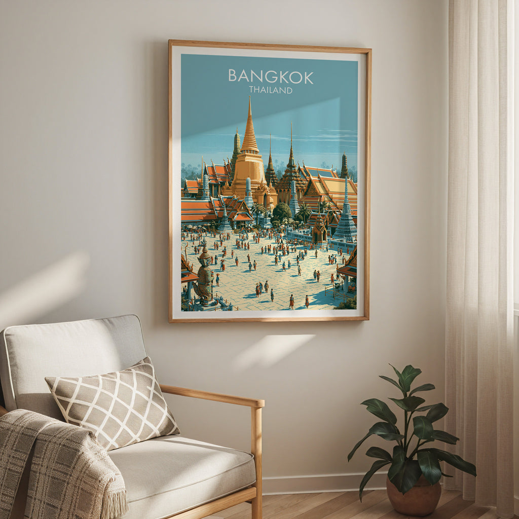 Grand Palace Bangkok Thailand travel print in a light oak frame on a living room wall beside a linen armchair