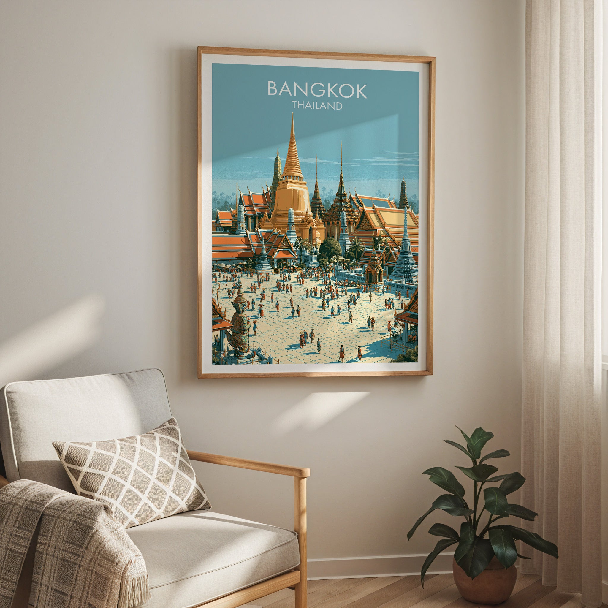 Grand Palace Bangkok Thailand travel print in a light oak frame on a living room wall beside a linen armchair
