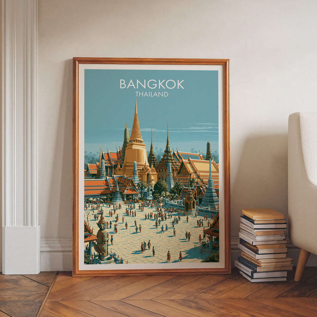 Thailand landmark travel poster in a walnut frame leaning on a herringbone floor beside a stack of books