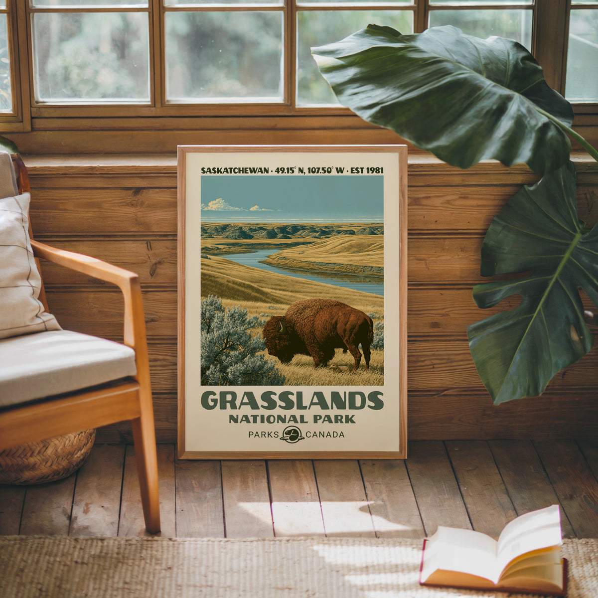 Grasslands Canada vintage poster in an oak frame against a pine cabin wall beside a monstera