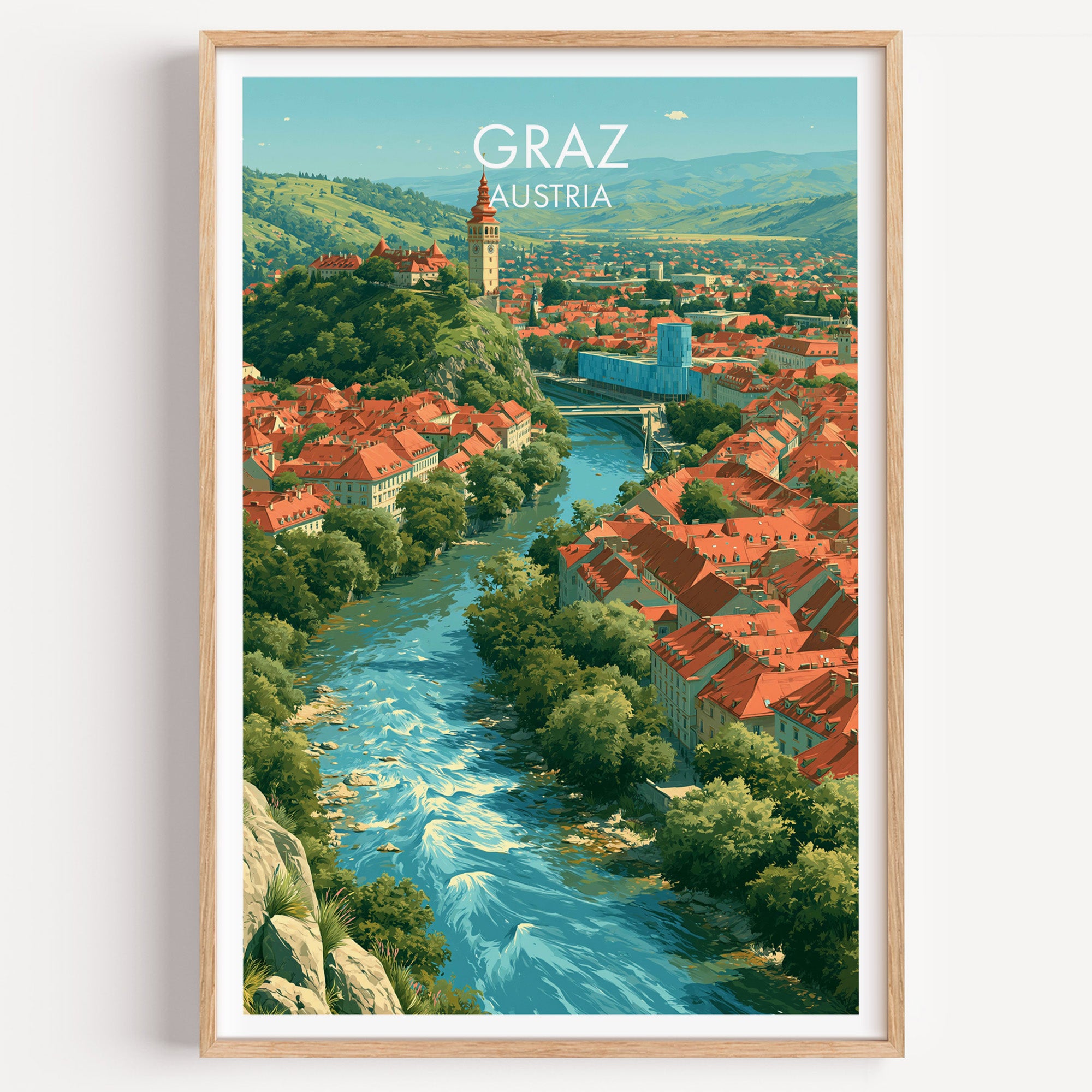 A framed travel poster of Graz, Austria, featuring a retro-style illustration of the city with a winding blue river, red-roofed buildings, green hills, and a tower, displayed in a light wood frame against a white wall.