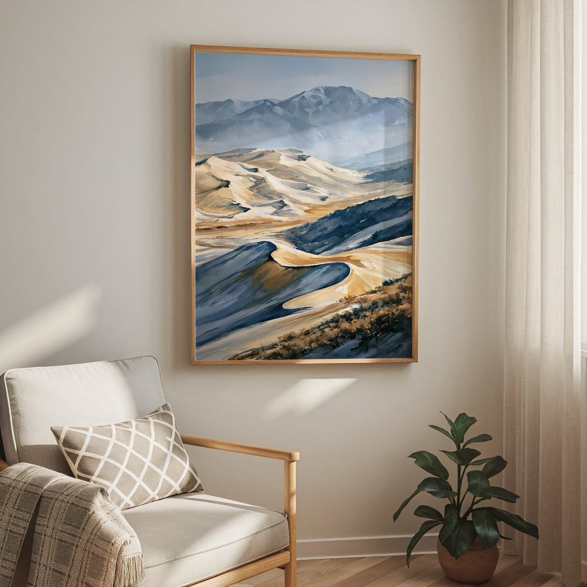Oak-framed Great Sand Dunes National Park watercolor print hung above a cream armchair in a bright living room