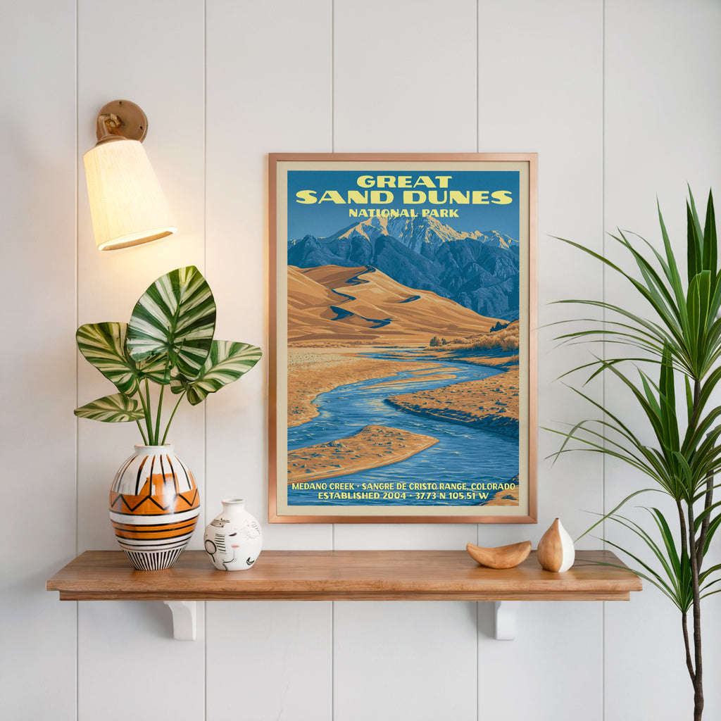 Great Sand Dunes print framed on white panelling above a floating oak shelf with a patterned vase and brass sconce