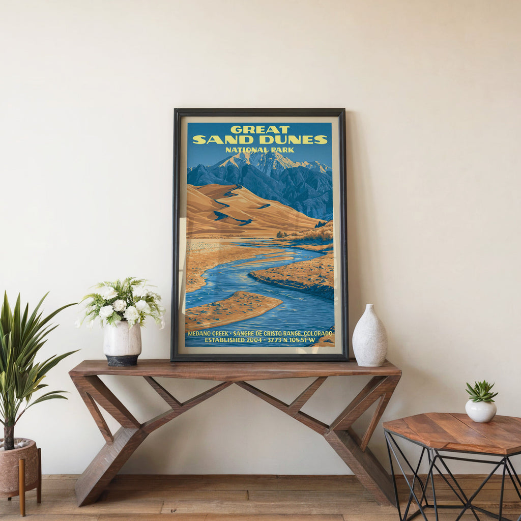 Medano Creek wall art in a black frame, leaning on a walnut console with white anemones in a stoneware vase