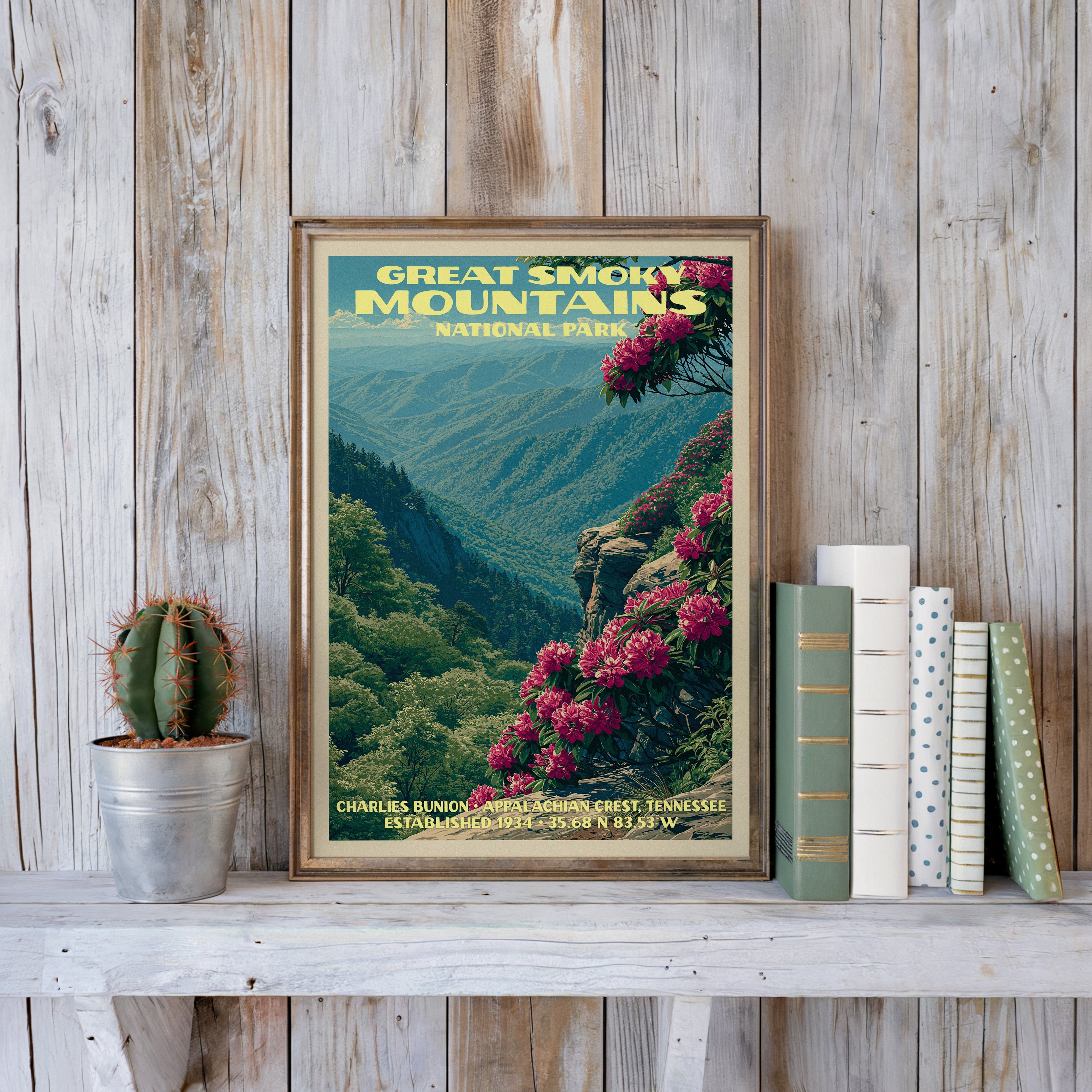 Charlies Bunion poster in a slim gold frame on a whitewashed plank wall beside a tin-potted cactus and pastel books