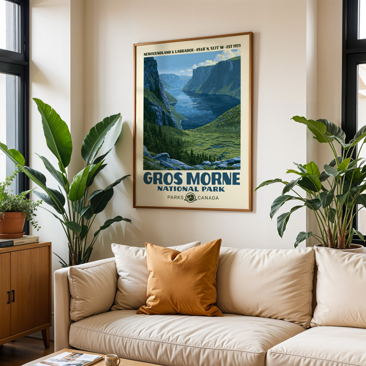 Gros Morne National Park print in an oak frame above a cream sofa with a rust cushion