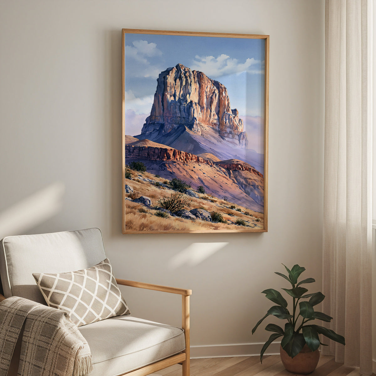 Oak-framed Guadalupe Mountains watercolor print hung above a cream armchair in a bright living room