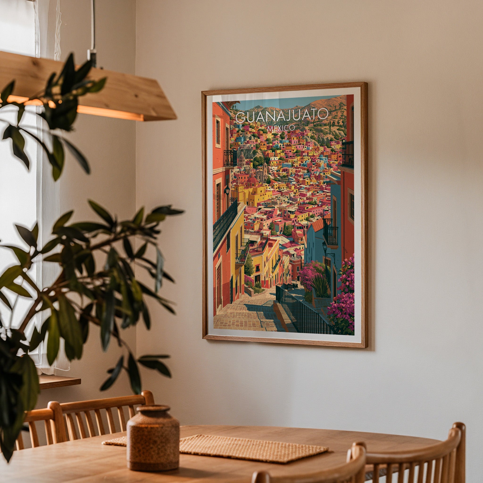 Mexican hill town poster in an oak frame in a dining corner with oak table, spindle chairs and pendant lamp
