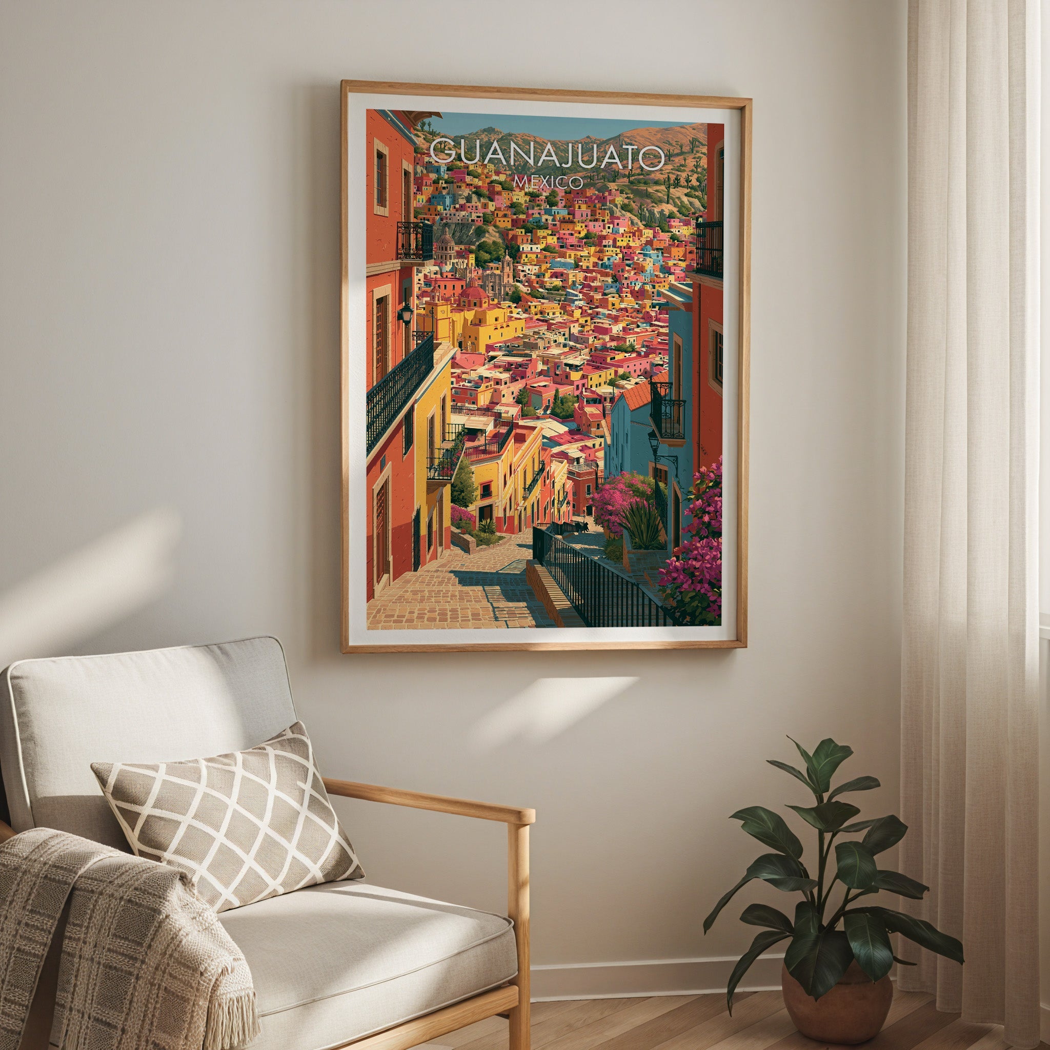 Terracotta and turquoise rooftops in an oak frame above a cream armchair with a check cushion and sheer curtain