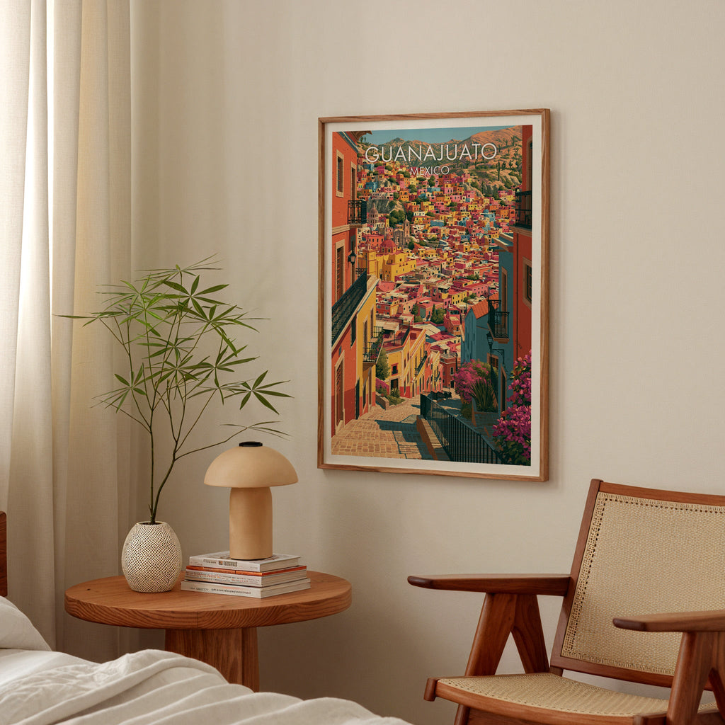 Warm coral cityscape in an oak frame above a round bedside table with a mushroom lamp and bamboo stems