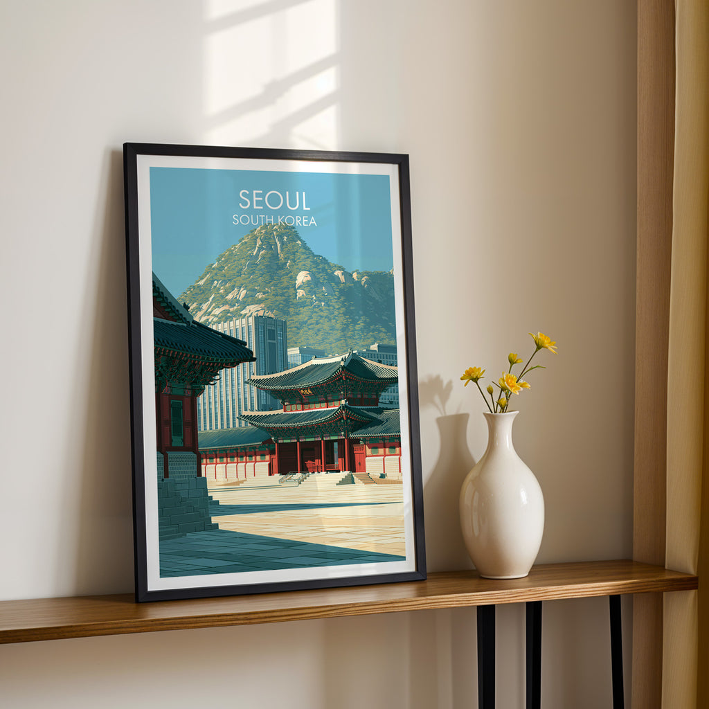 Black framed Gyeongbokgung Palace Seoul print on a narrow hallway console in sunlight, styled with yellow flowers