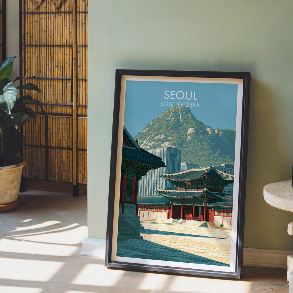 Gyeongbokgung Palace Seoul wall art in a black frame leaning against a sage green wall beside a bamboo screen