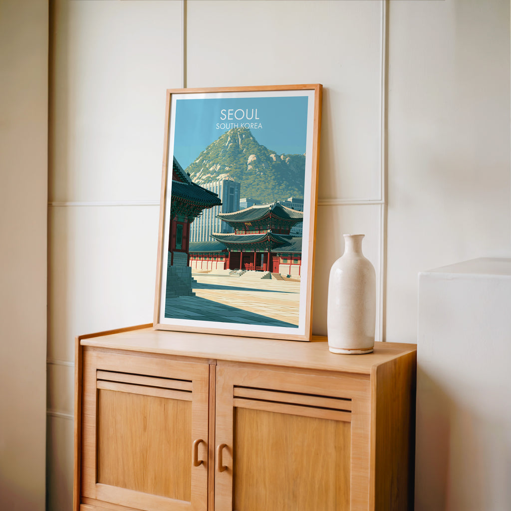 Small Gyeongbokgung Palace Seoul travel poster in an oak frame on a mid-century sideboard with a ceramic vase