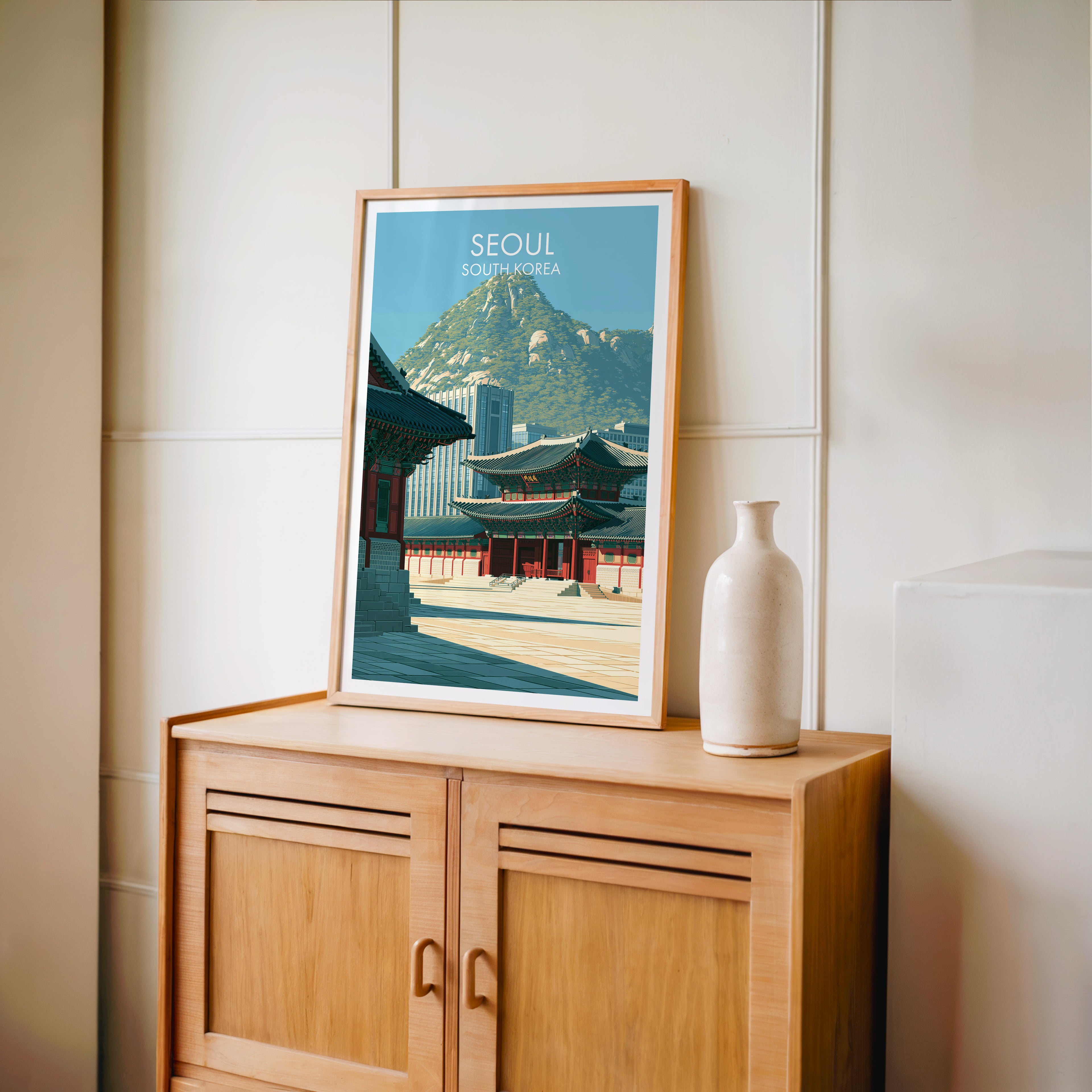 Small Gyeongbokgung Palace Seoul travel poster in an oak frame on a mid-century sideboard with a ceramic vase