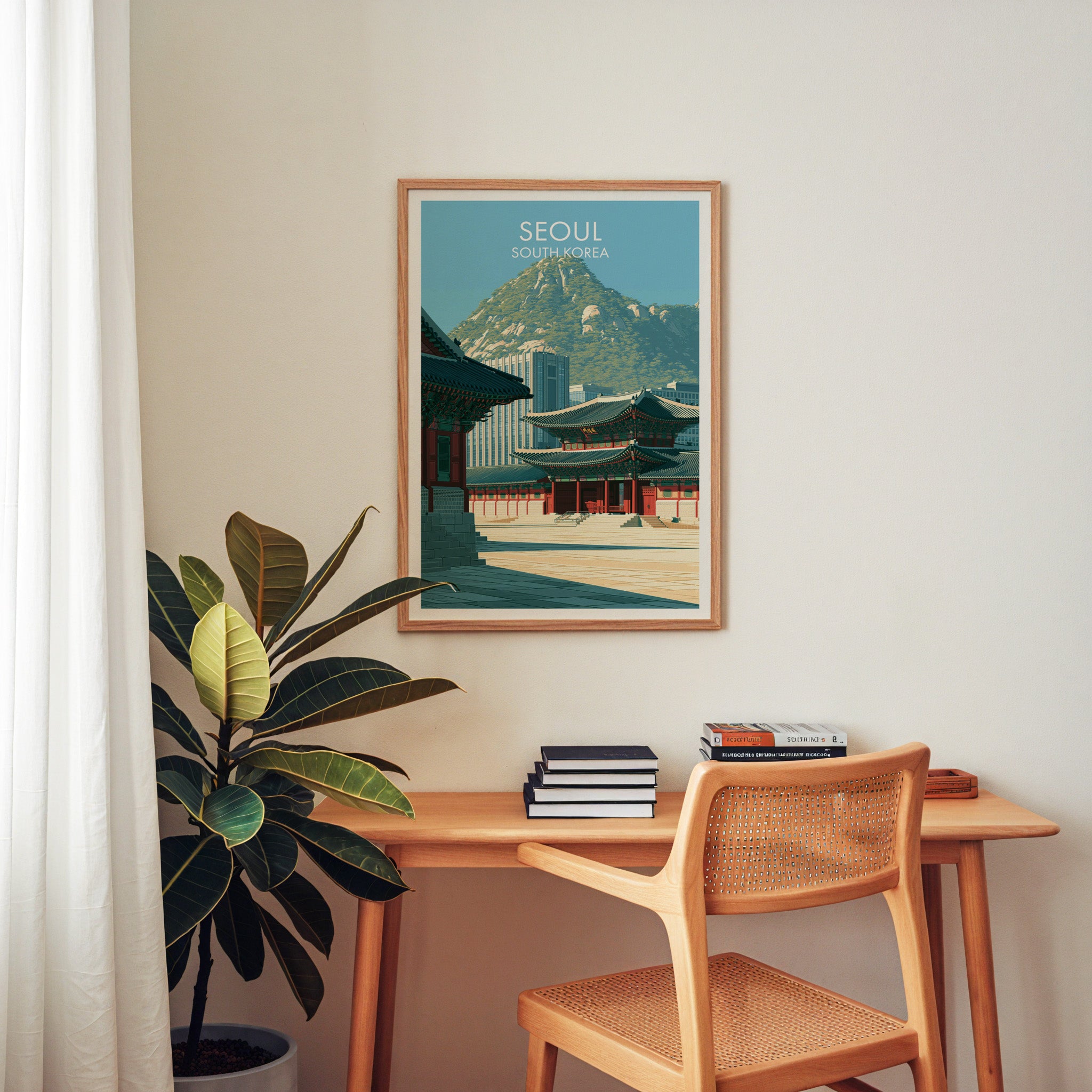 Gyeongbokgung Palace Seoul wall art above a wooden home office desk with a rattan chair and books