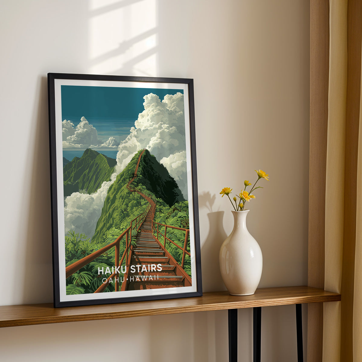 Haiku Stairs print in a black frame on a narrow console beside a white vase of yellow flowers