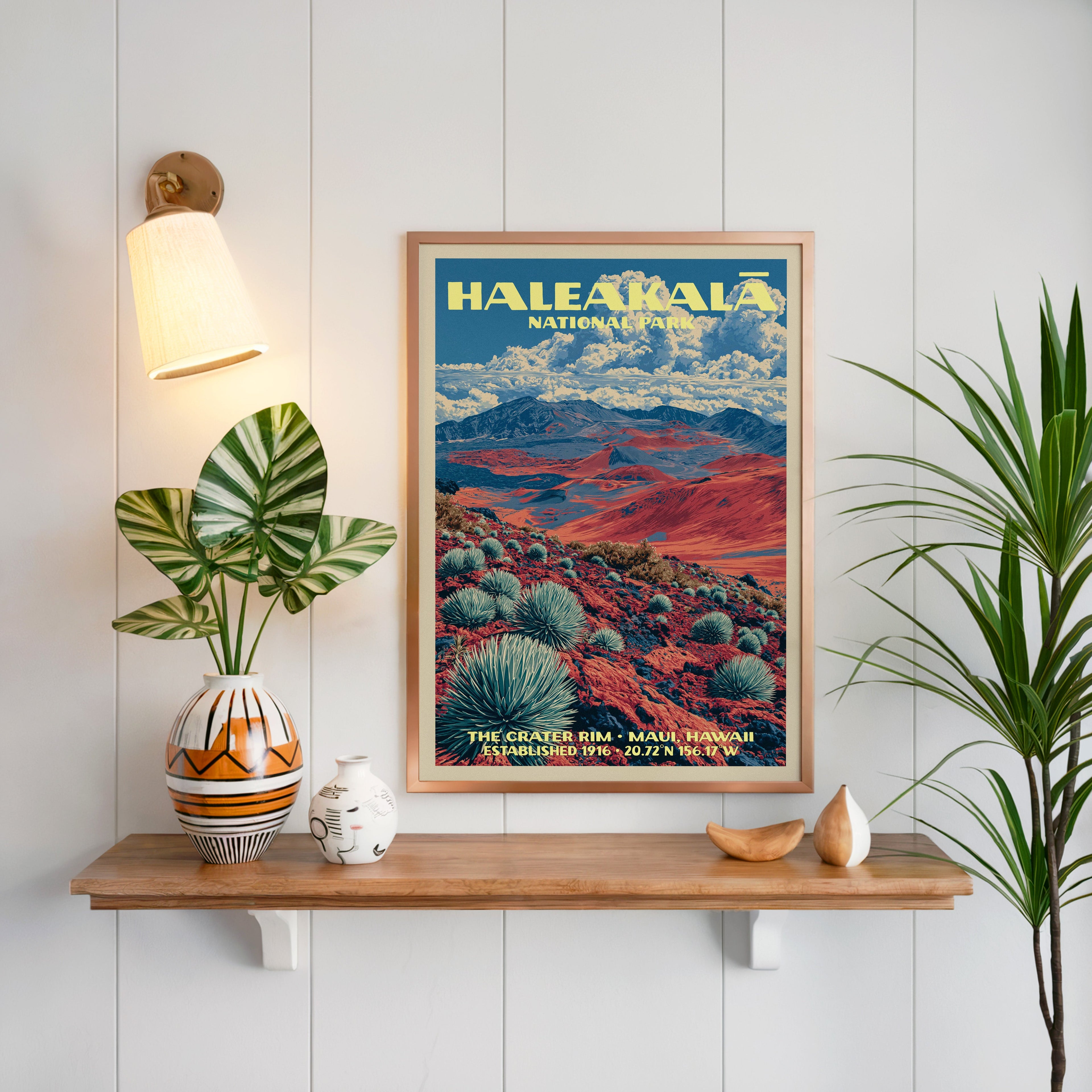 Haleakalā print framed on white panelling above a floating oak shelf with a patterned vase and brass sconce