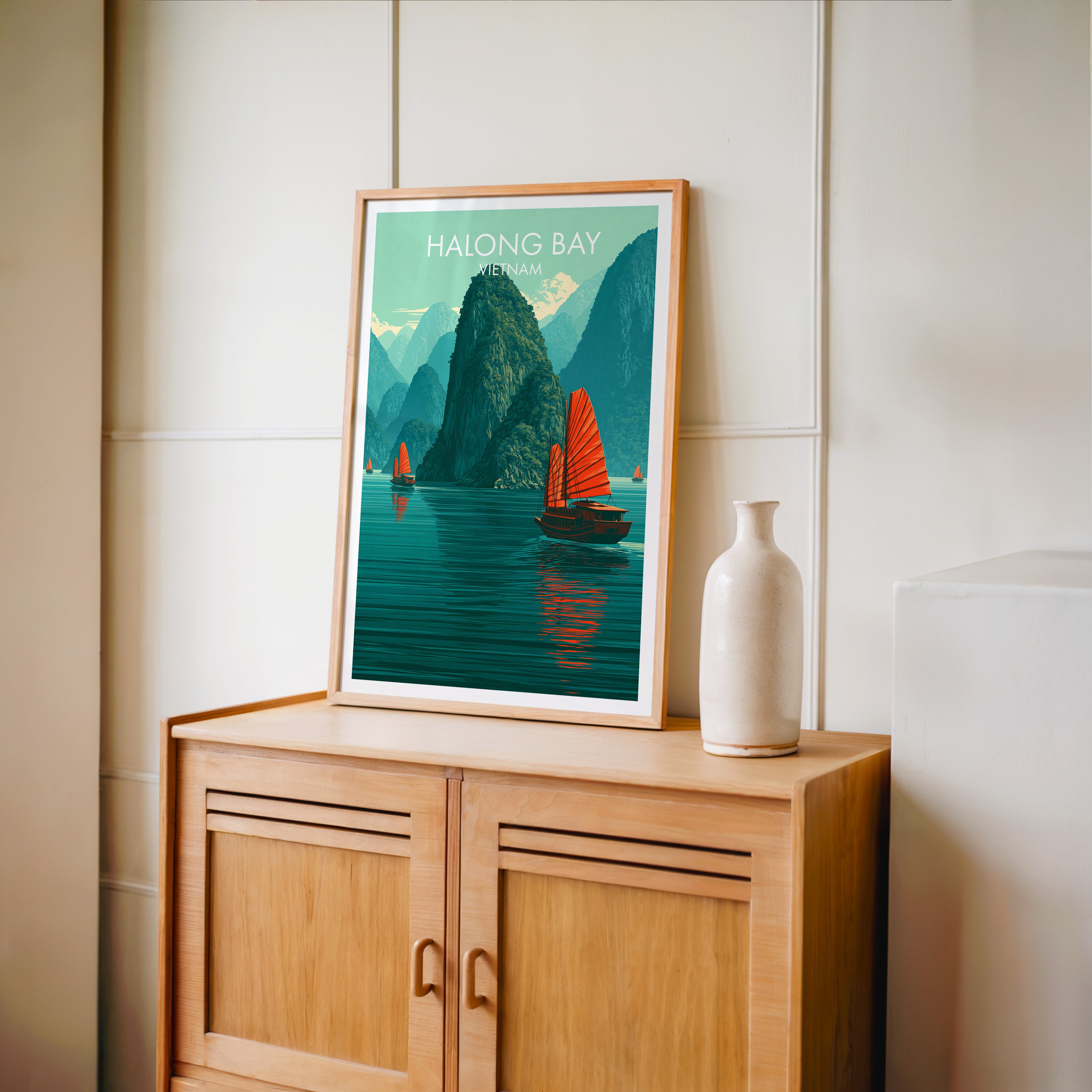 Small Halong Bay Vietnam travel poster in an oak frame on a mid-century sideboard with a ceramic vase