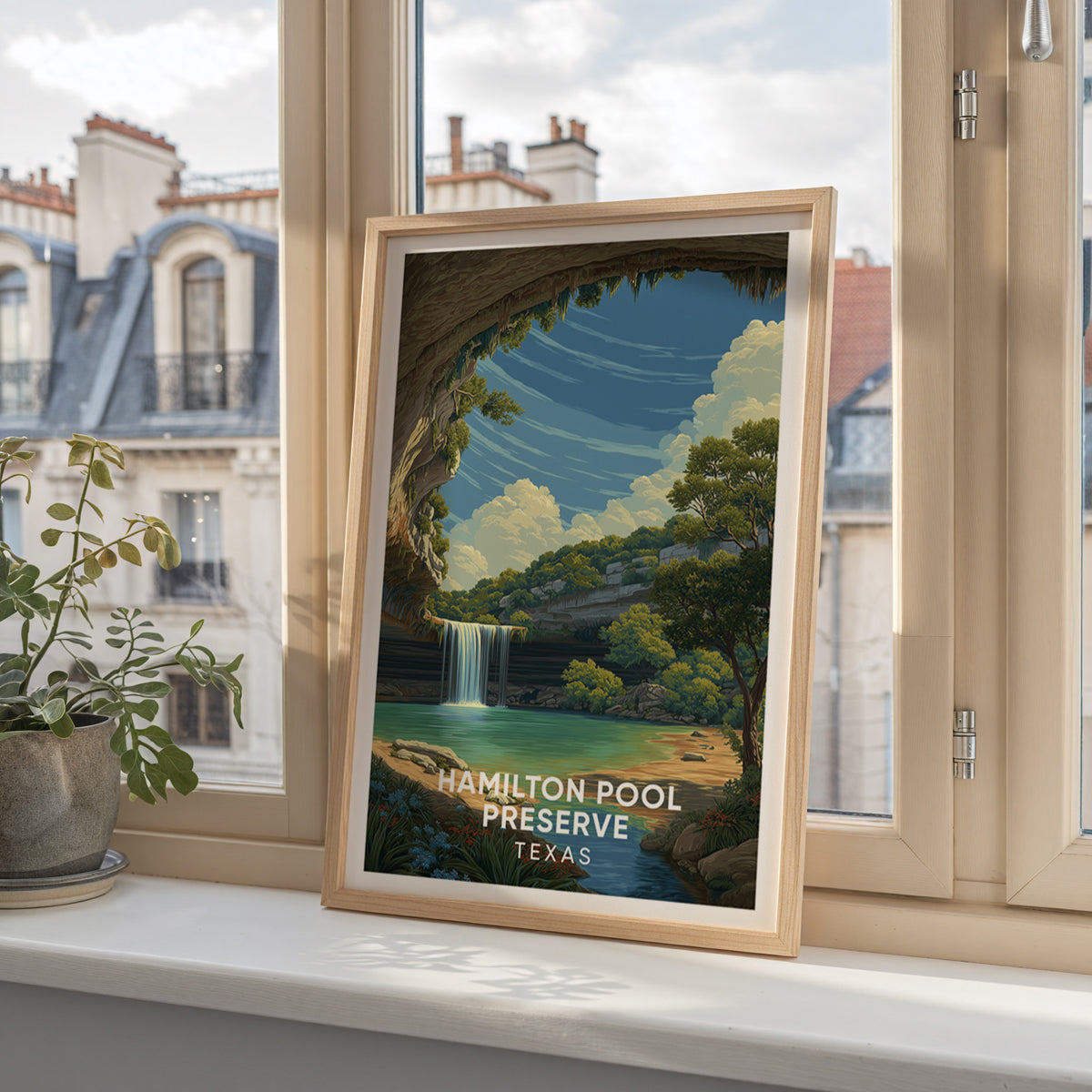 Hamilton Pool Preserve poster in oak on a windowsill overlooking Parisian mansard rooftops