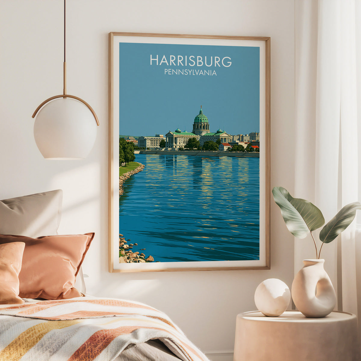 Harrisburg Pennsylvania wall art in a large oak frame over a bed with a rust throw