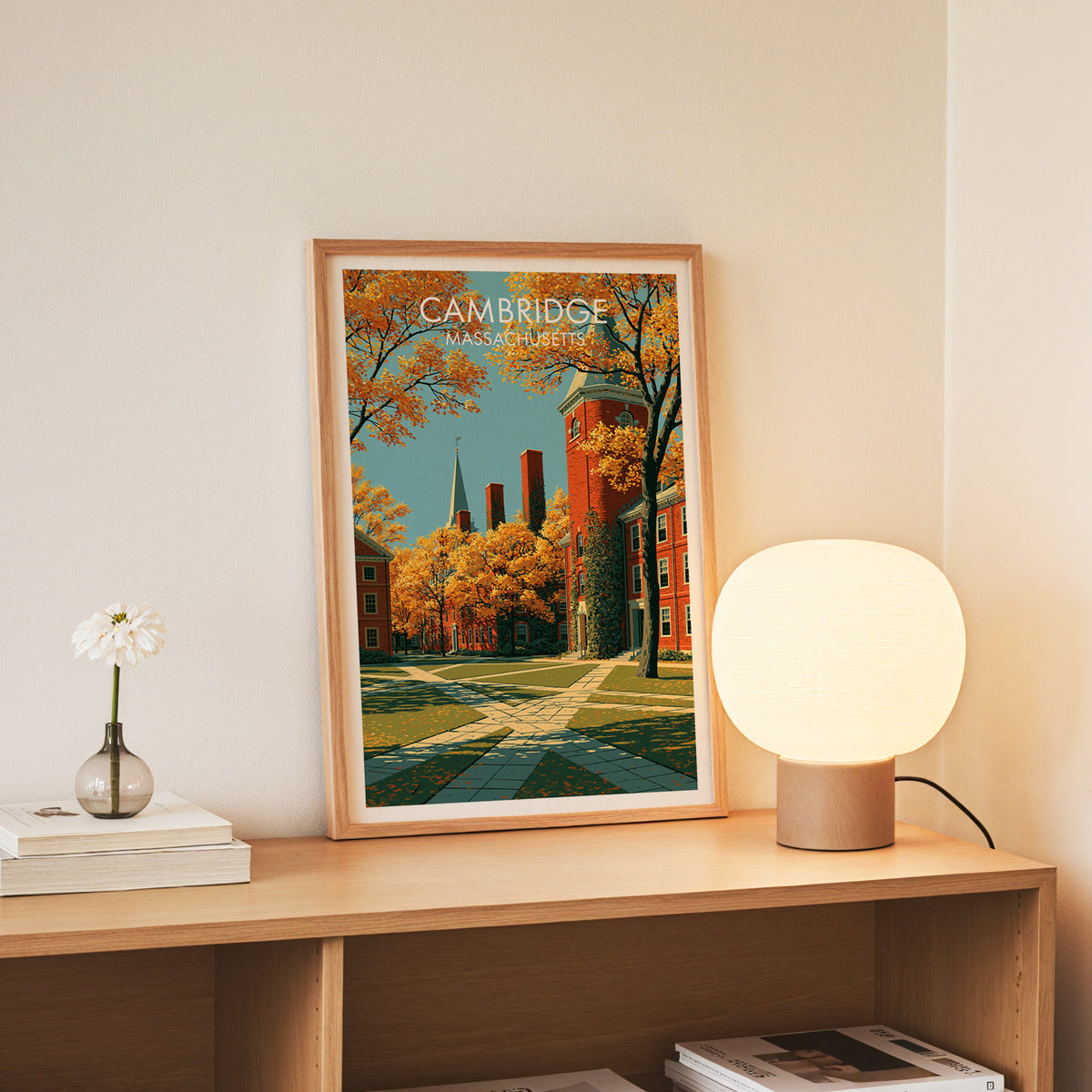Slim oak framed Cambridge Massachusetts art standing on an oak console beside white daisies in a glass jar