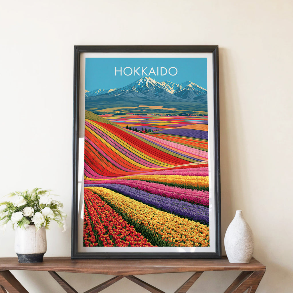 Hokkaido Japan travel poster in a black frame on a wooden console table with white flowers