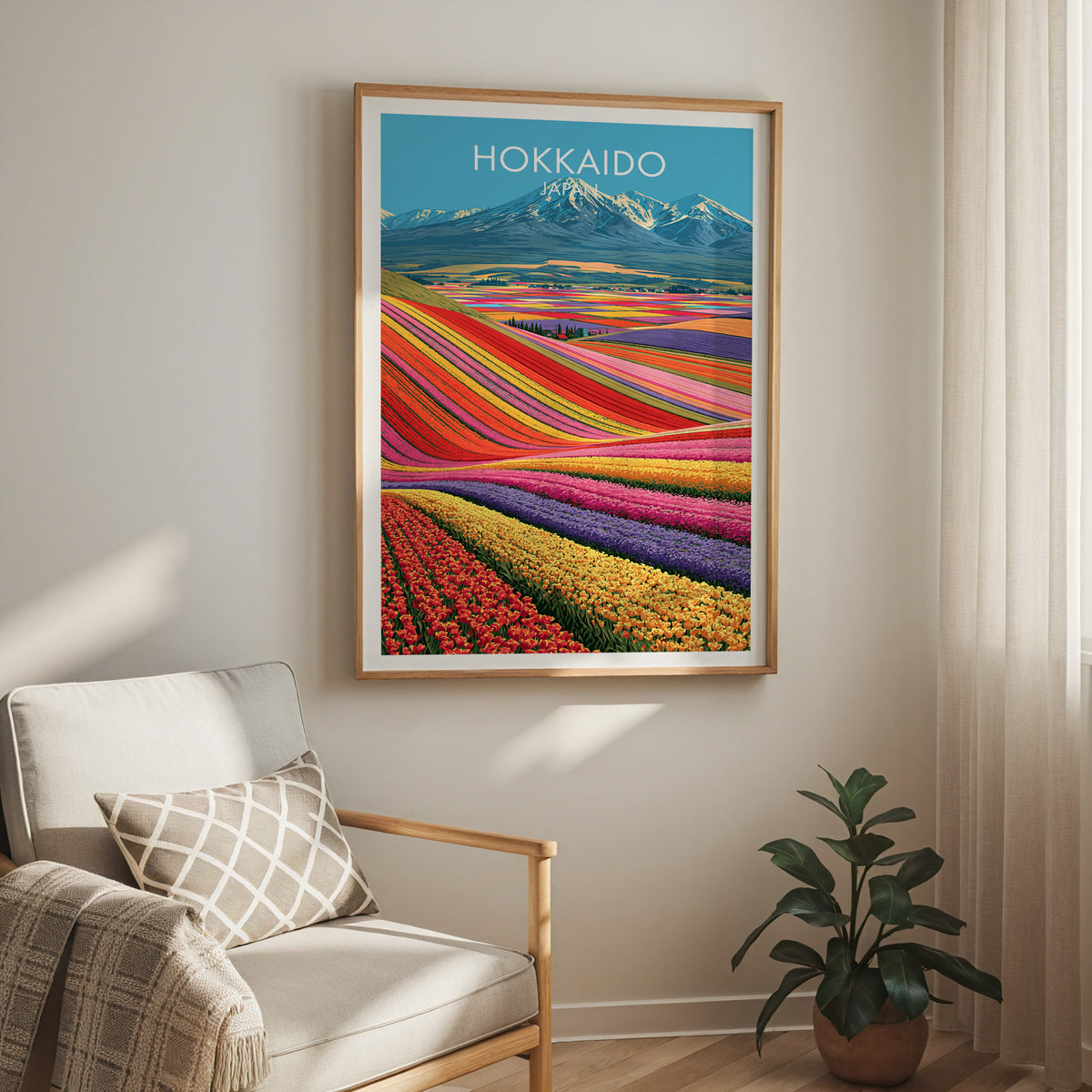 Hokkaido landscape travel print in an oak frame above a cream armchair with sheer curtains and a rubber plant