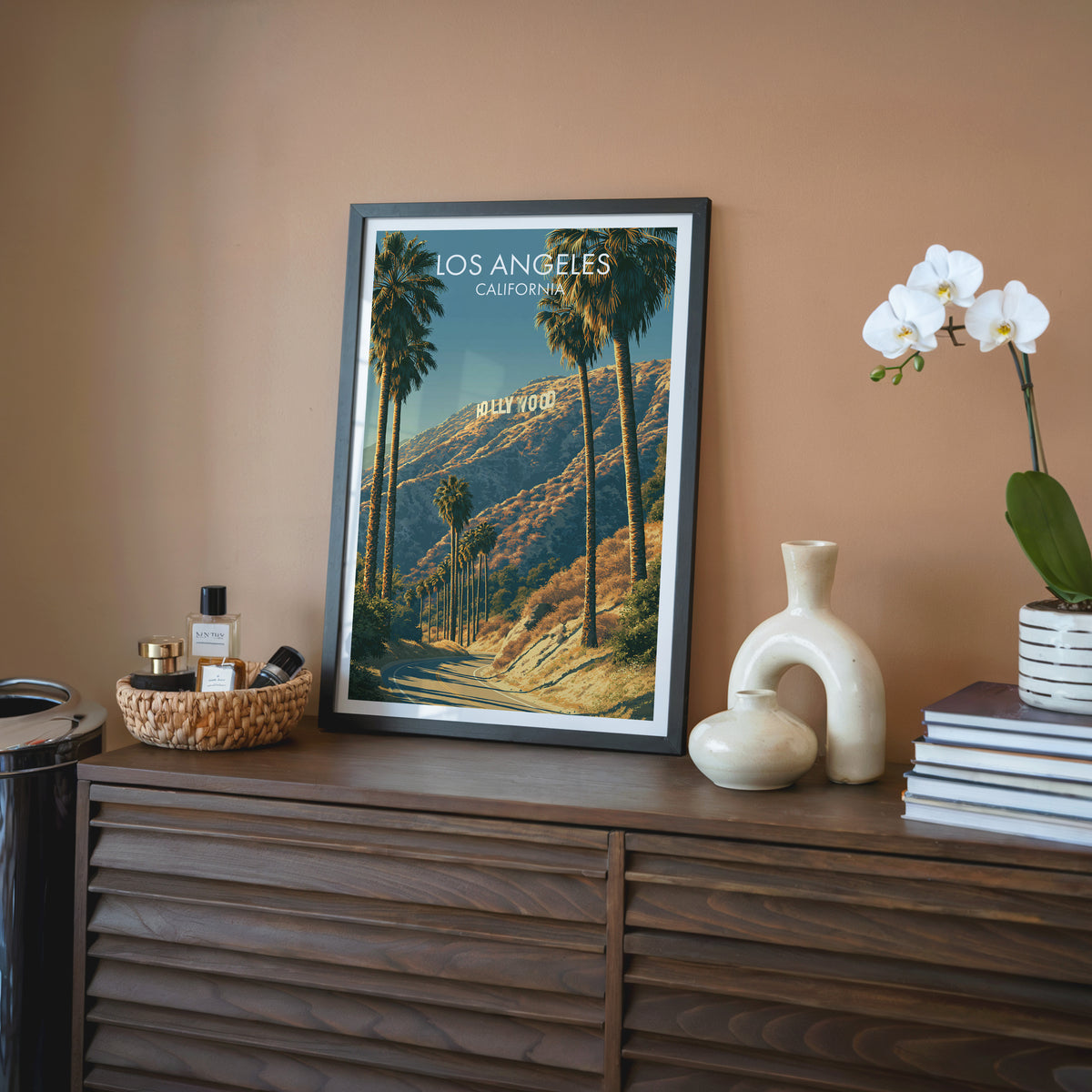 Hollywood Sign wall art in a black frame on a walnut sideboard with a cream vase and rattan tray.