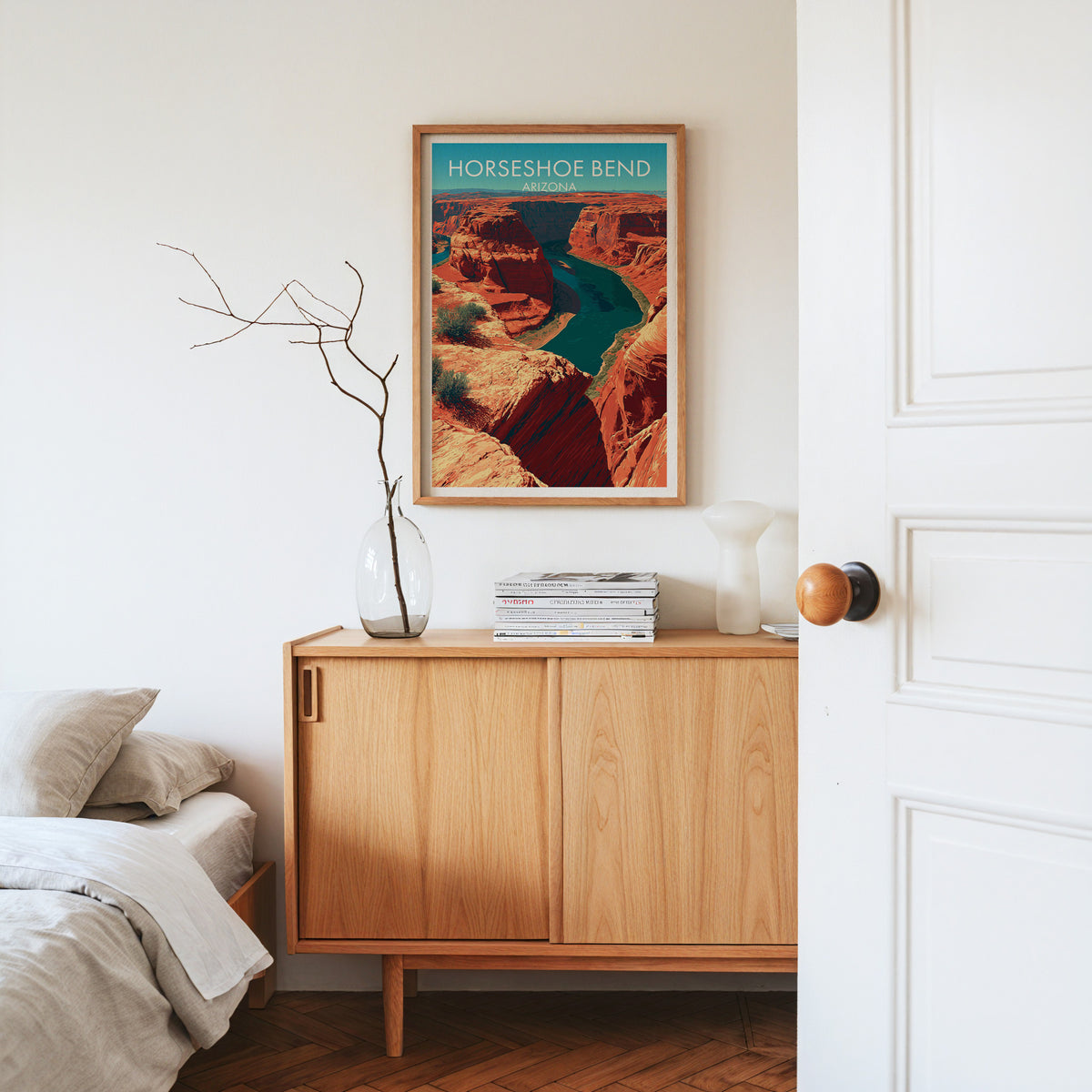 Horseshoe Bend wall print in an oak frame on a pale oak sideboard with dried branches and a white vase
