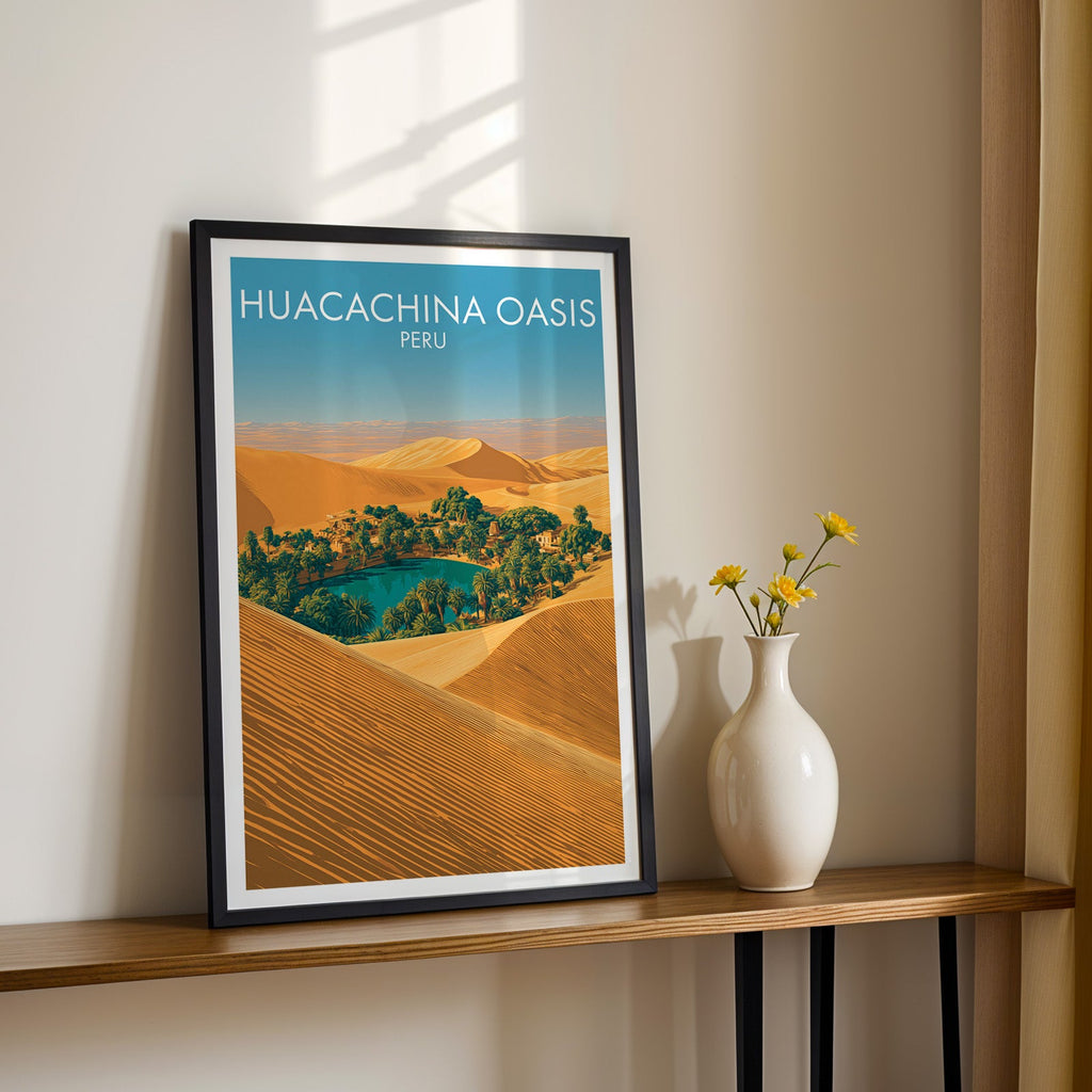Peru sand dunes wall art in a black frame on a narrow wood shelf beside yellow daisies in a white vase