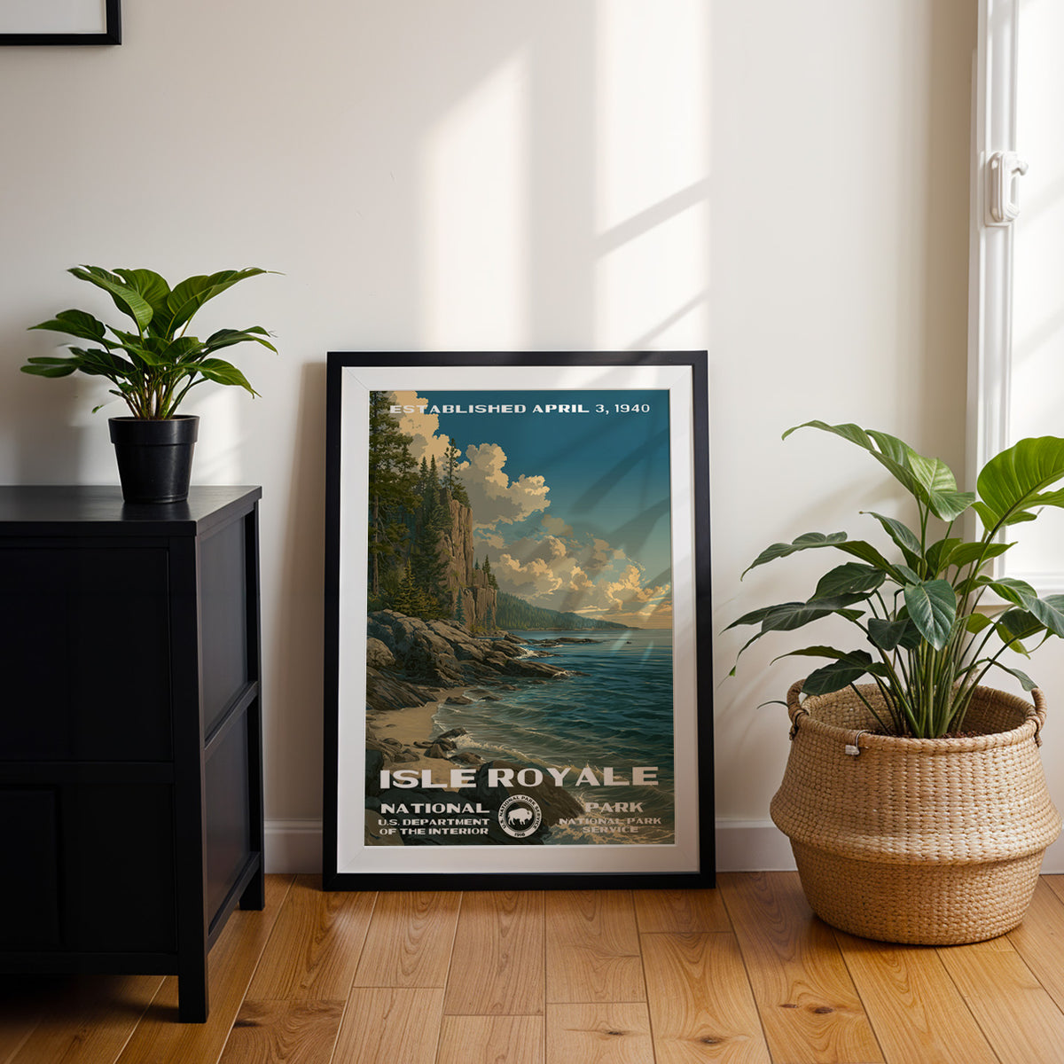 Isle Royale National Park travel poster in a black frame leaning by a dark cabinet and plants