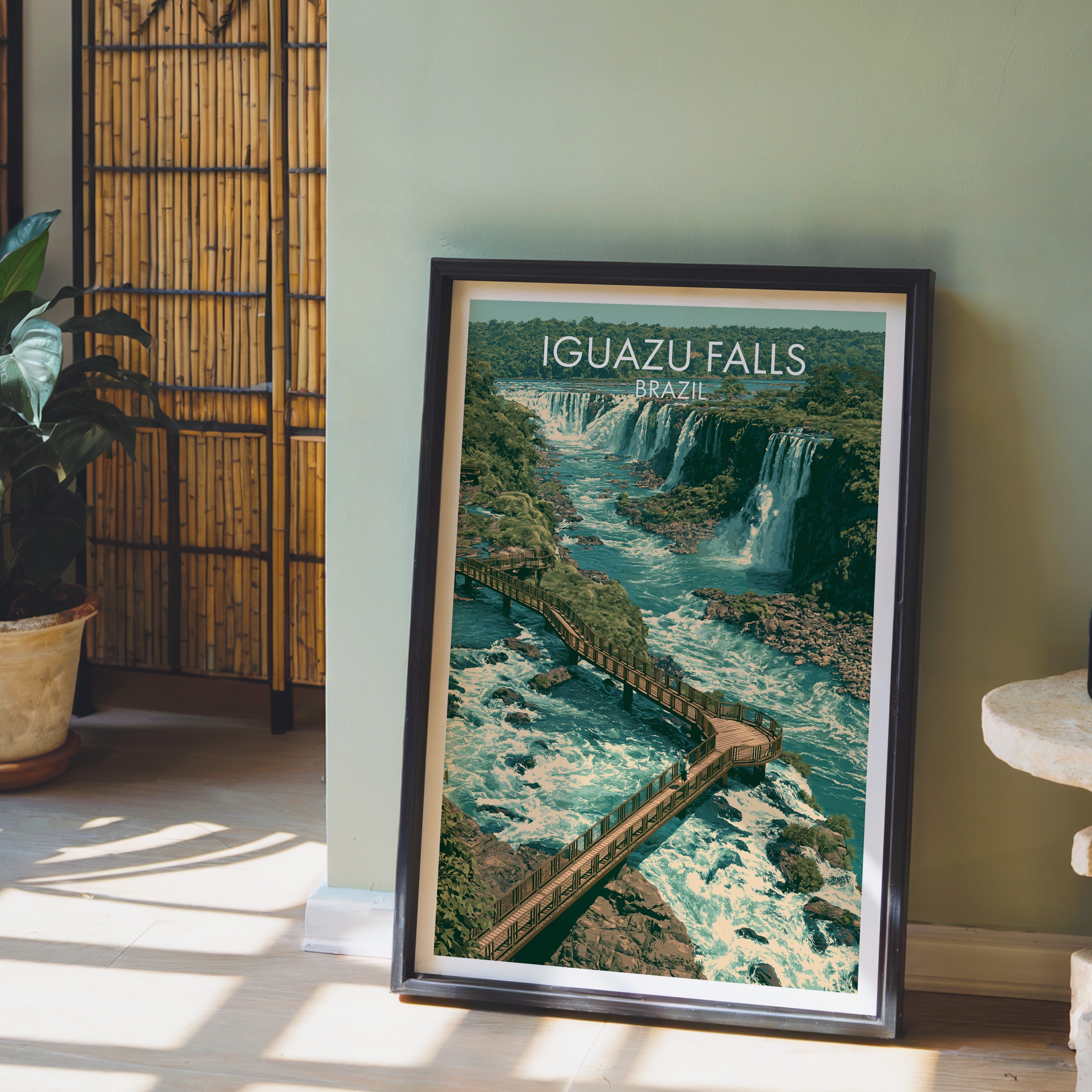 Iguazu rapids print in a dark brown frame on light wood floor by a sage green wall and bamboo screen