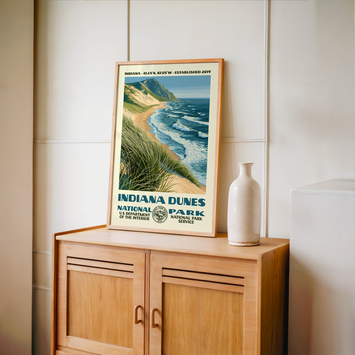 Indiana Dunes National Park WPA print framed in light oak on a wooden sideboard with a ceramic vase