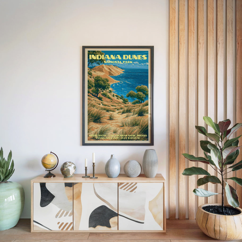 Indiana Dunes National Park poster in a black frame above a light wood sideboard with a globe and a candlestick