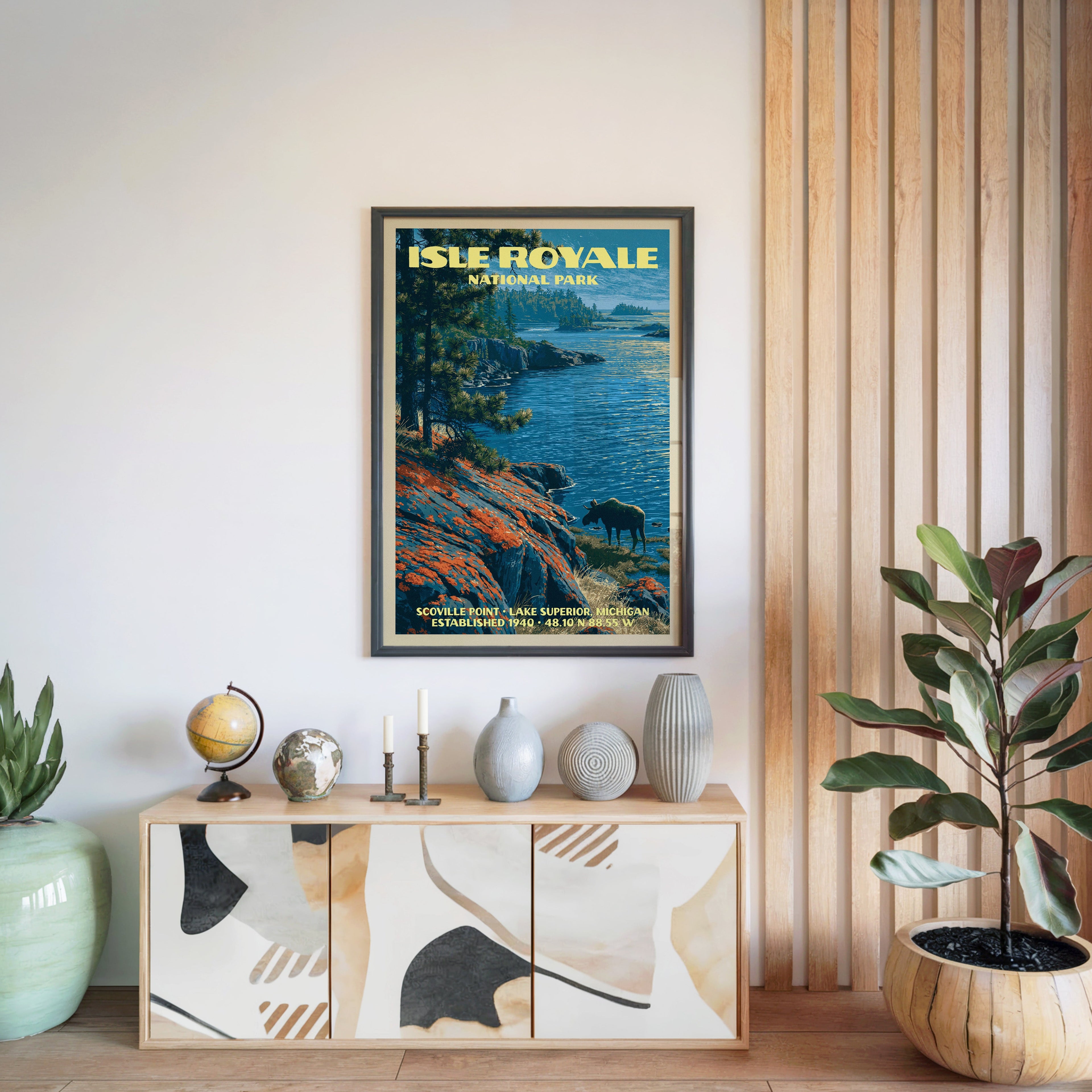 Isle Royale National Park poster in a black frame above a light wood sideboard by a slatted wall panel