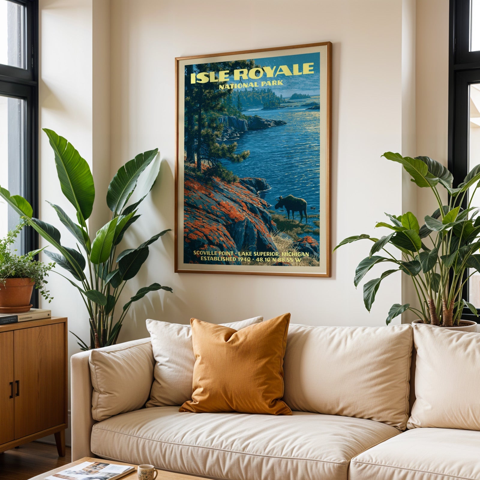 Isle Royale vintage travel print in oak above a cream sofa with a rust cushion and tall houseplants