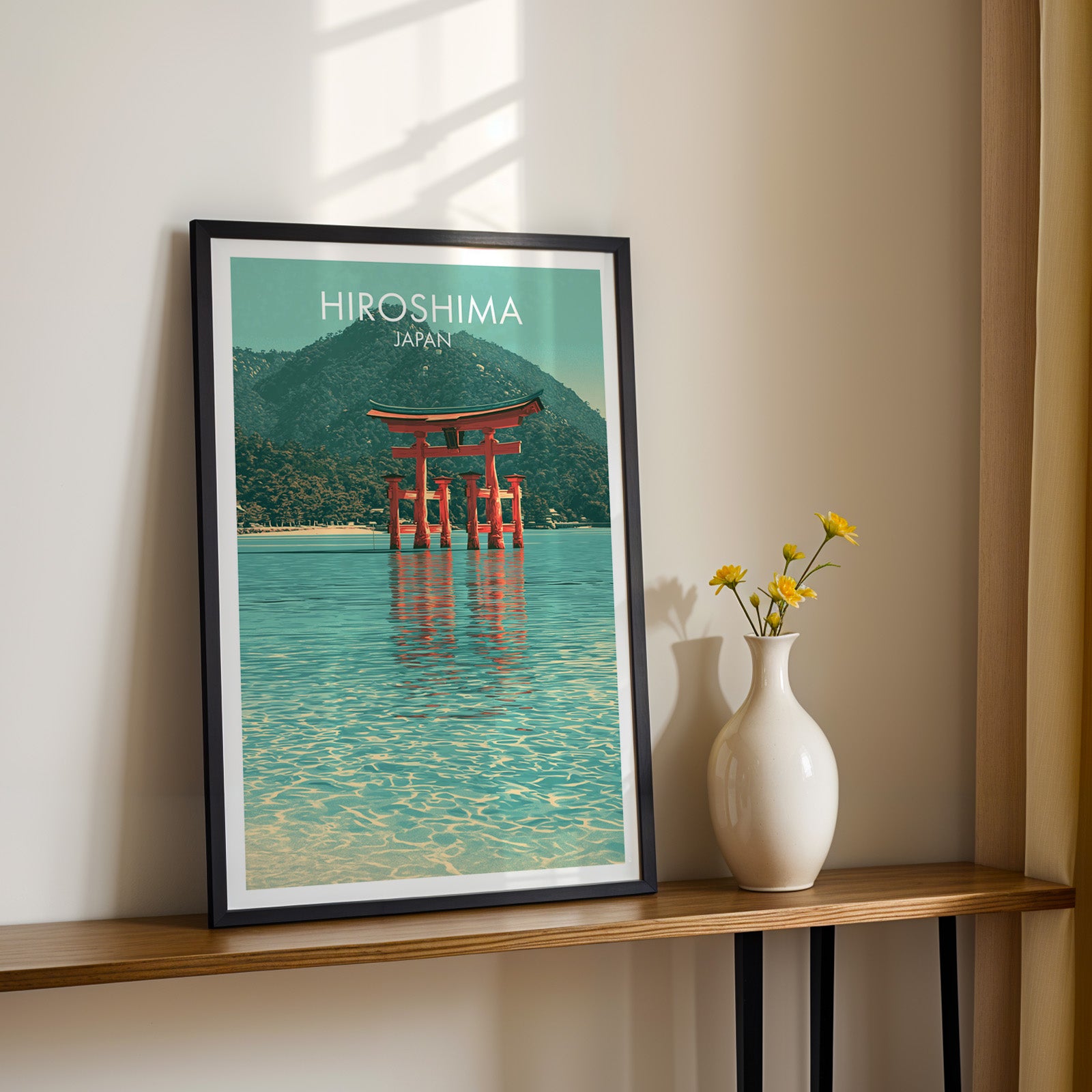 Black framed Itsukushima Shrine Miyajima Japan print on a narrow hallway console in sunlight, styled with yellow flowers