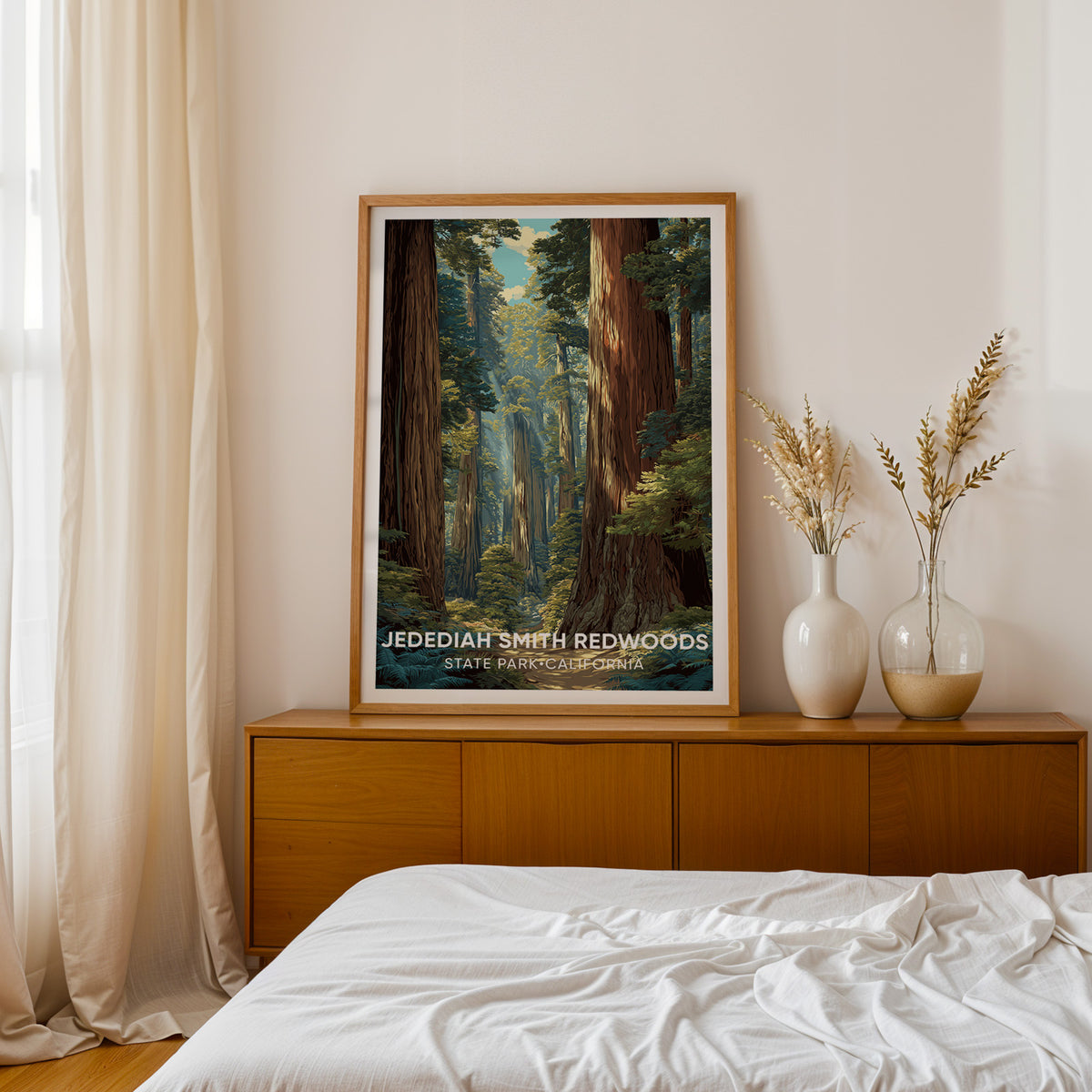 Jedediah Smith Redwoods print framed in oak on a teak sideboard beside a bed, dried pampas in two white vases.