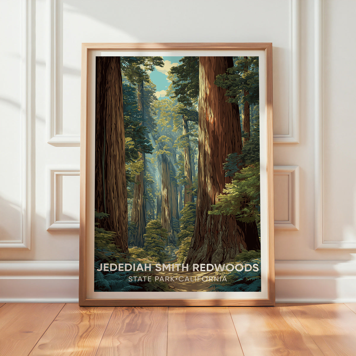 Redwood trail print in an oak frame resting on a wood floor against a textured white wall in raking sunlight.