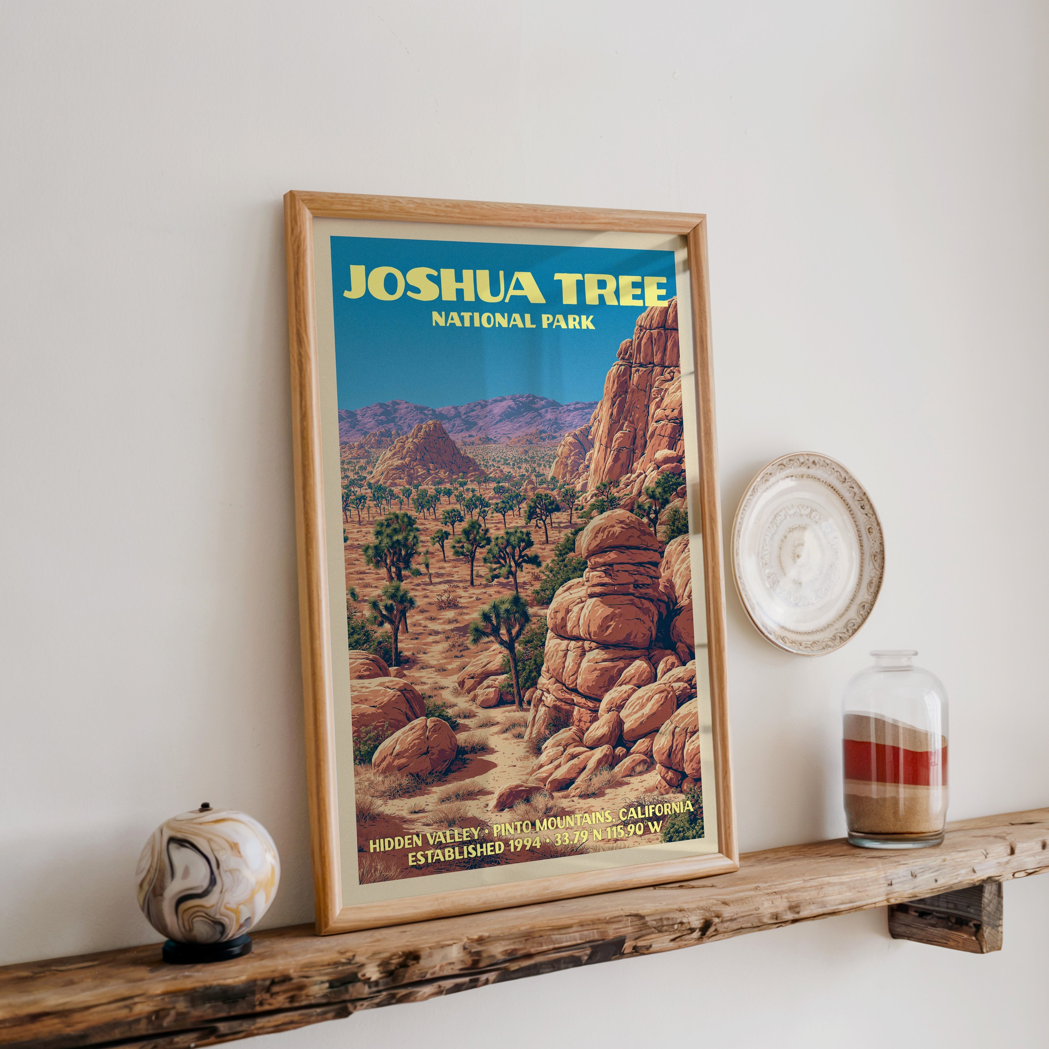 Joshua Tree Hidden Valley print in oak, leaning on a reclaimed wood ledge with a marbled sphere and sand jar
