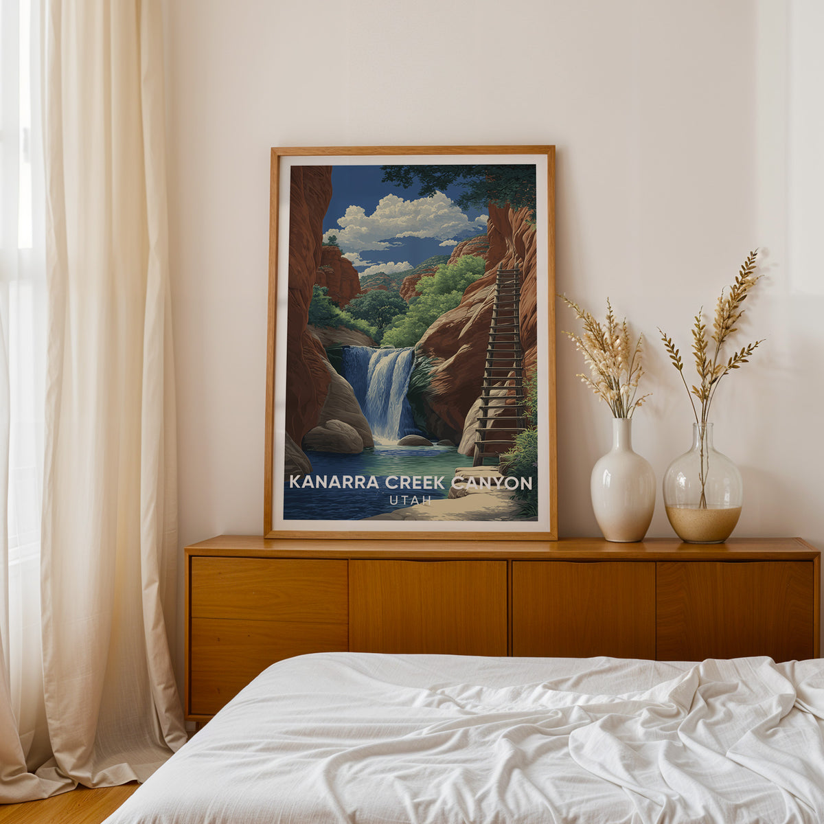 Kanarra Creek Falls print in oak on a teak sideboard next to a bed, dried pampas in two white vases.