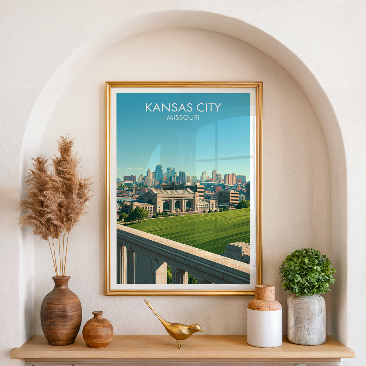 Kansas City wall art in a gold frame set in an arched niche with pampas grass and a brass bird