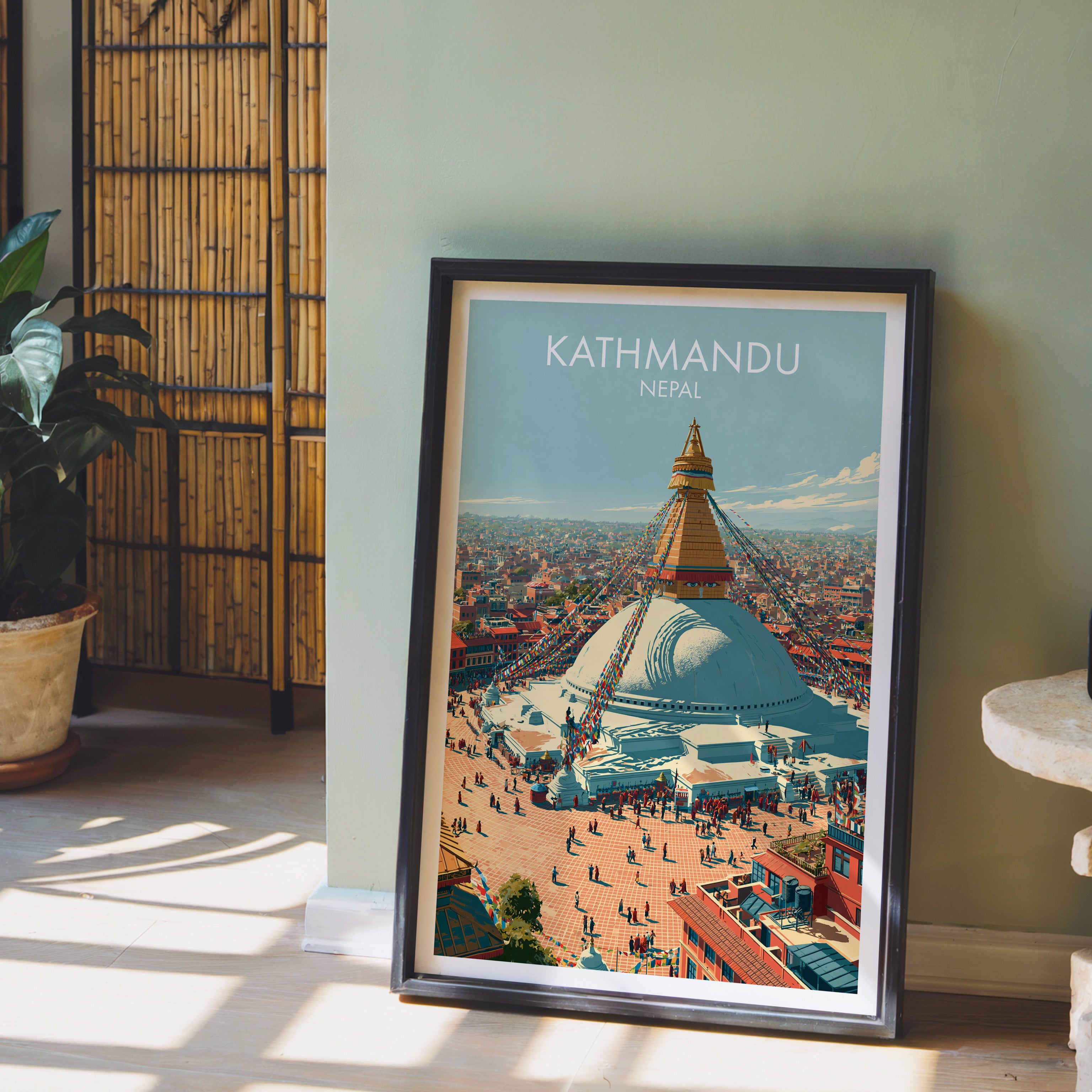 Kathmandu Nepal wall art in a black frame leaning against a sage green wall beside a bamboo screen
