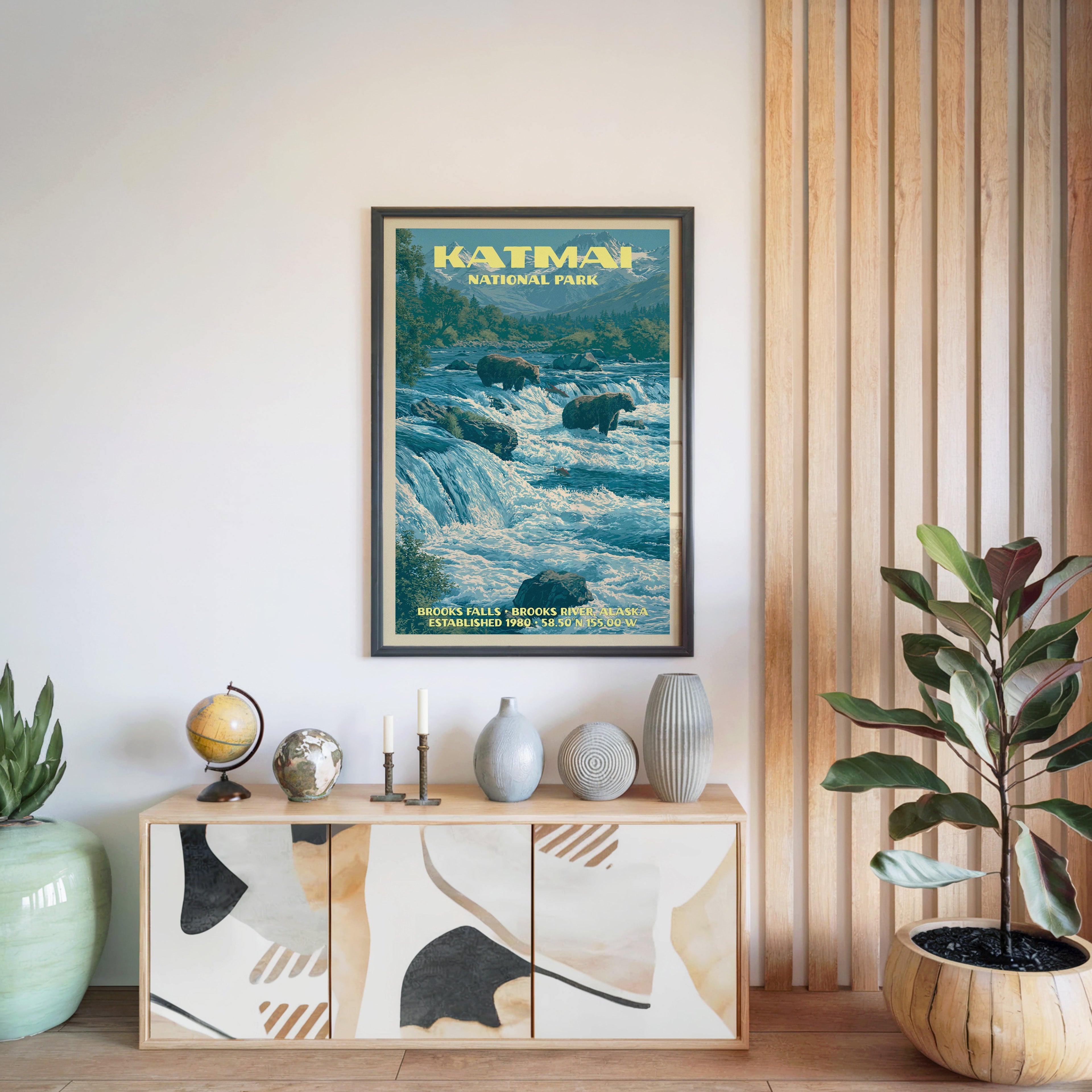 Katmai National Park poster in a black frame above a light wood sideboard by a slatted wall panel