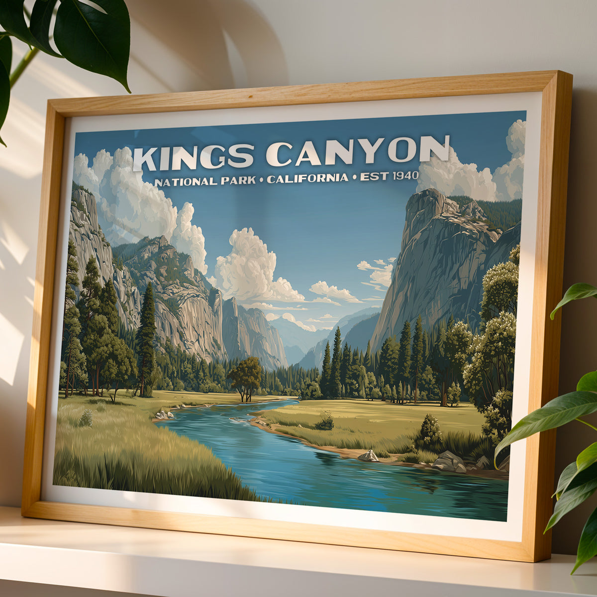 Kings Canyon National Park wall art print in a light oak frame, leaning on a white shelf in warm sunlight beside a monstera plant