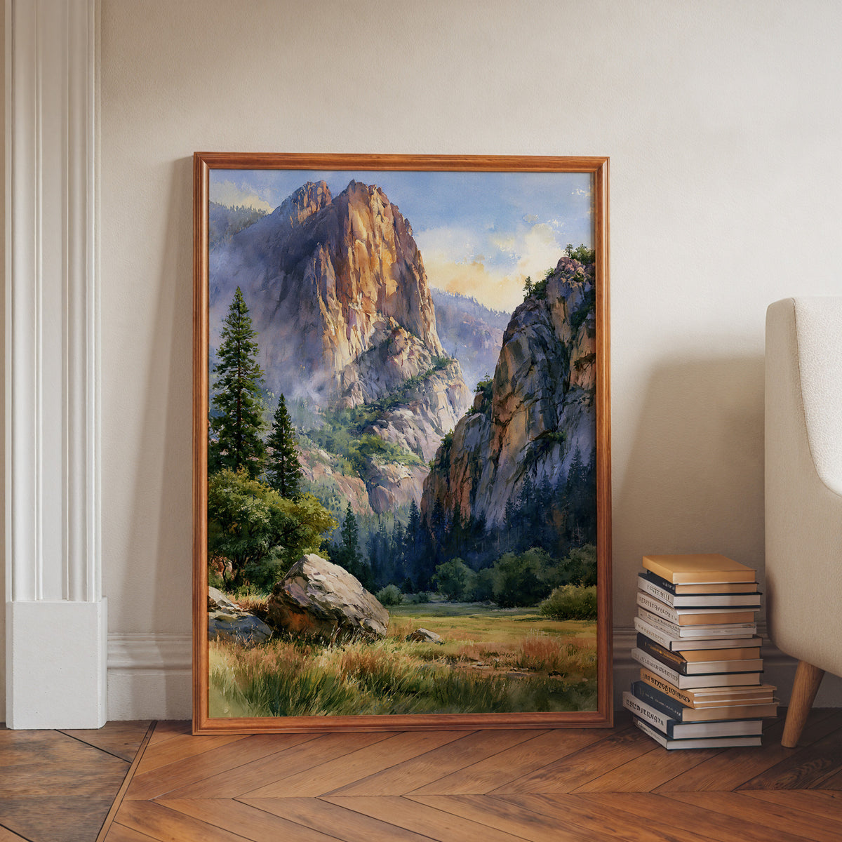 Kings Canyon National Park watercolor print in a walnut frame leaning on a herringbone floor beside stacked books