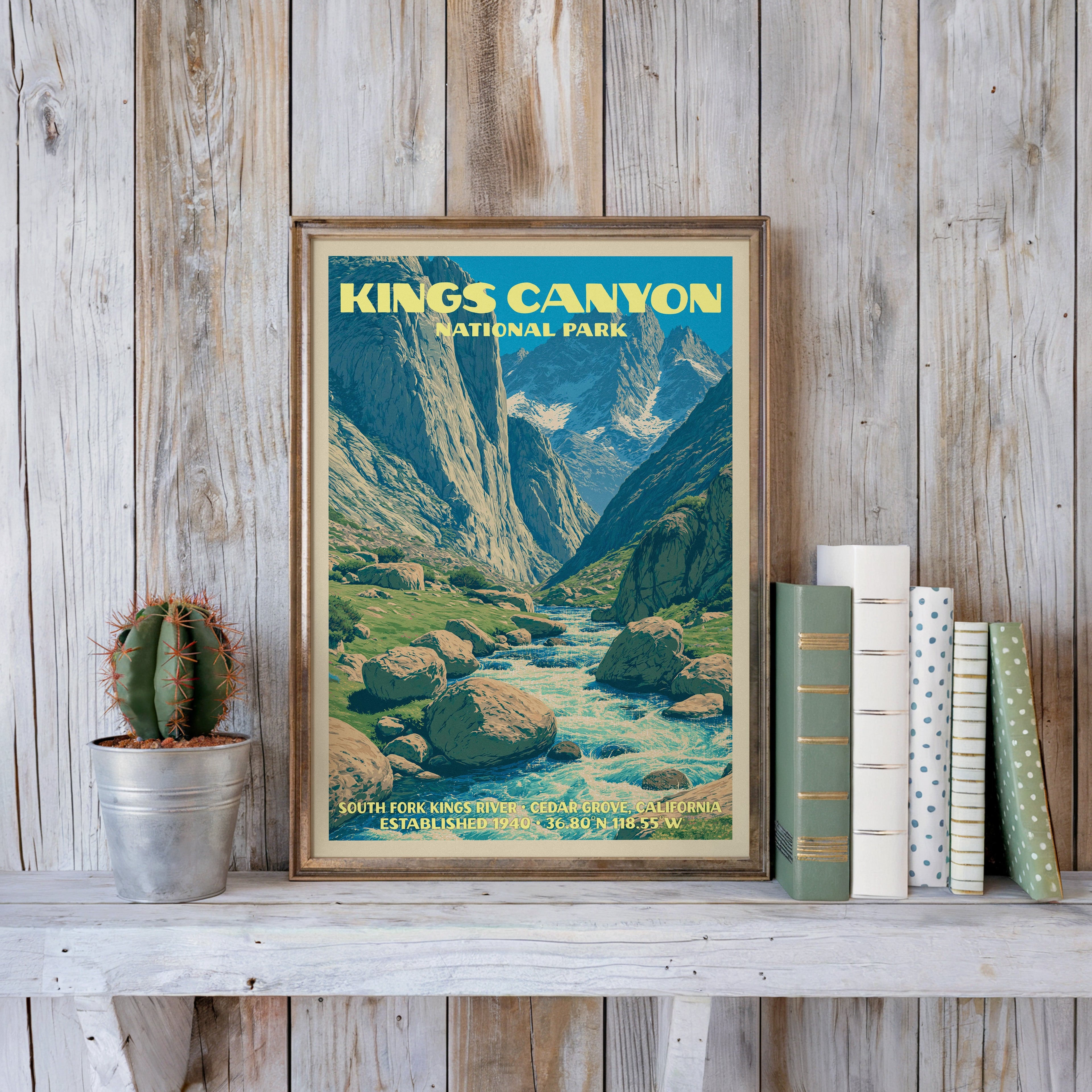 Kings Canyon vintage poster in a slim gold frame on a whitewashed plank wall beside a cactus and pastel books