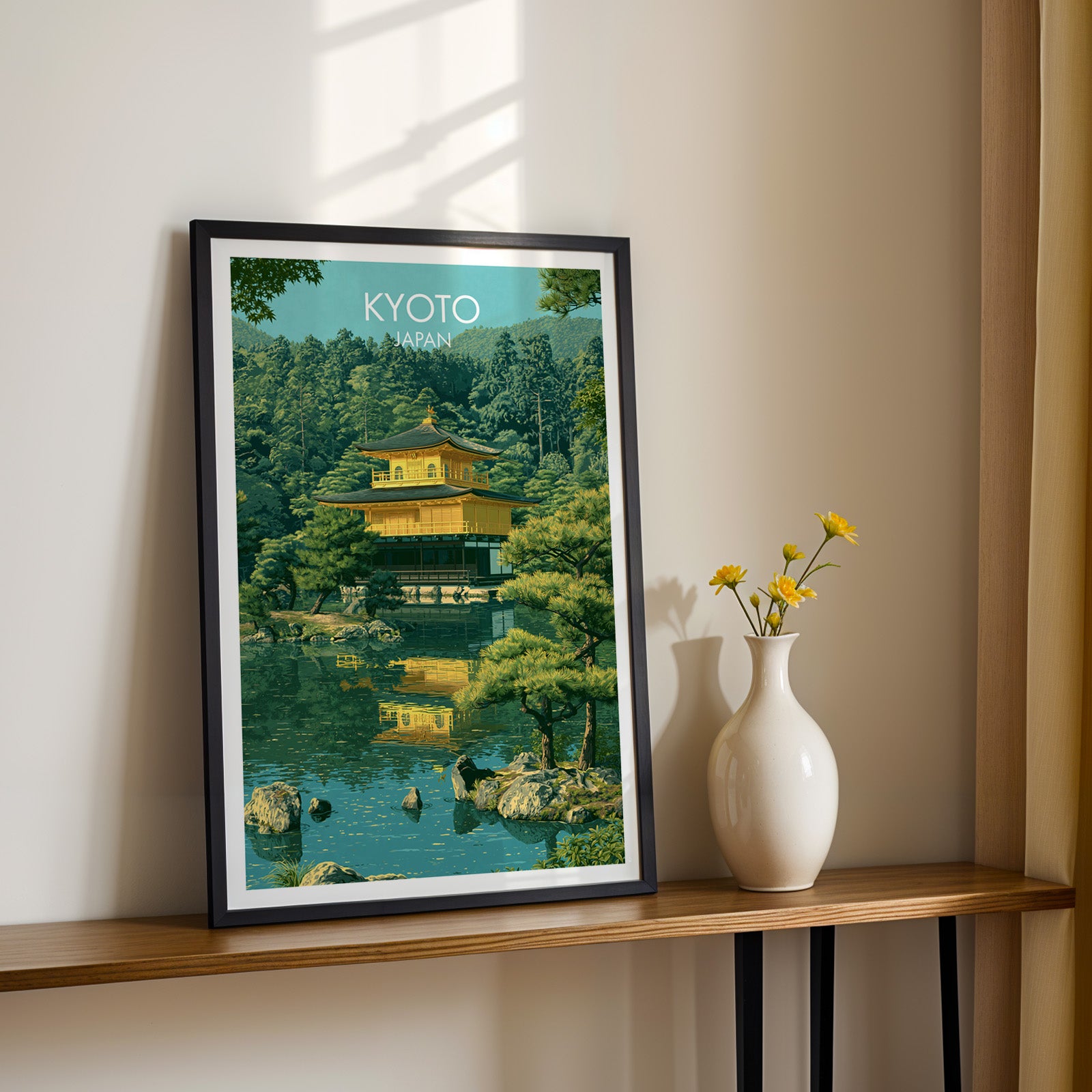Black framed Kinkakuji Golden Pavilion Kyoto print on a narrow hallway console in sunlight, styled with yellow flowers