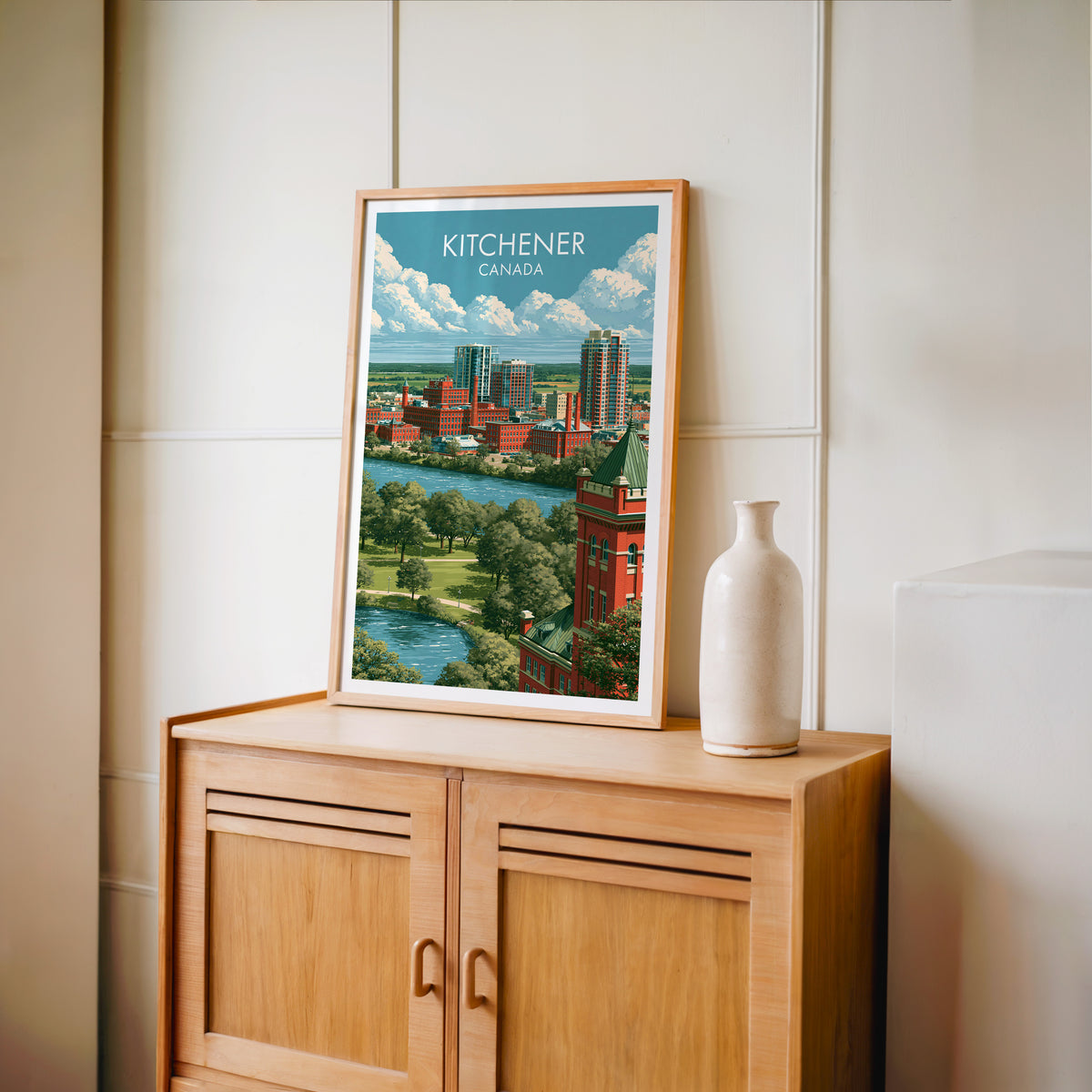 Kitchener river park wall art in an oak frame on a light wood cabinet beside a stoneware vase