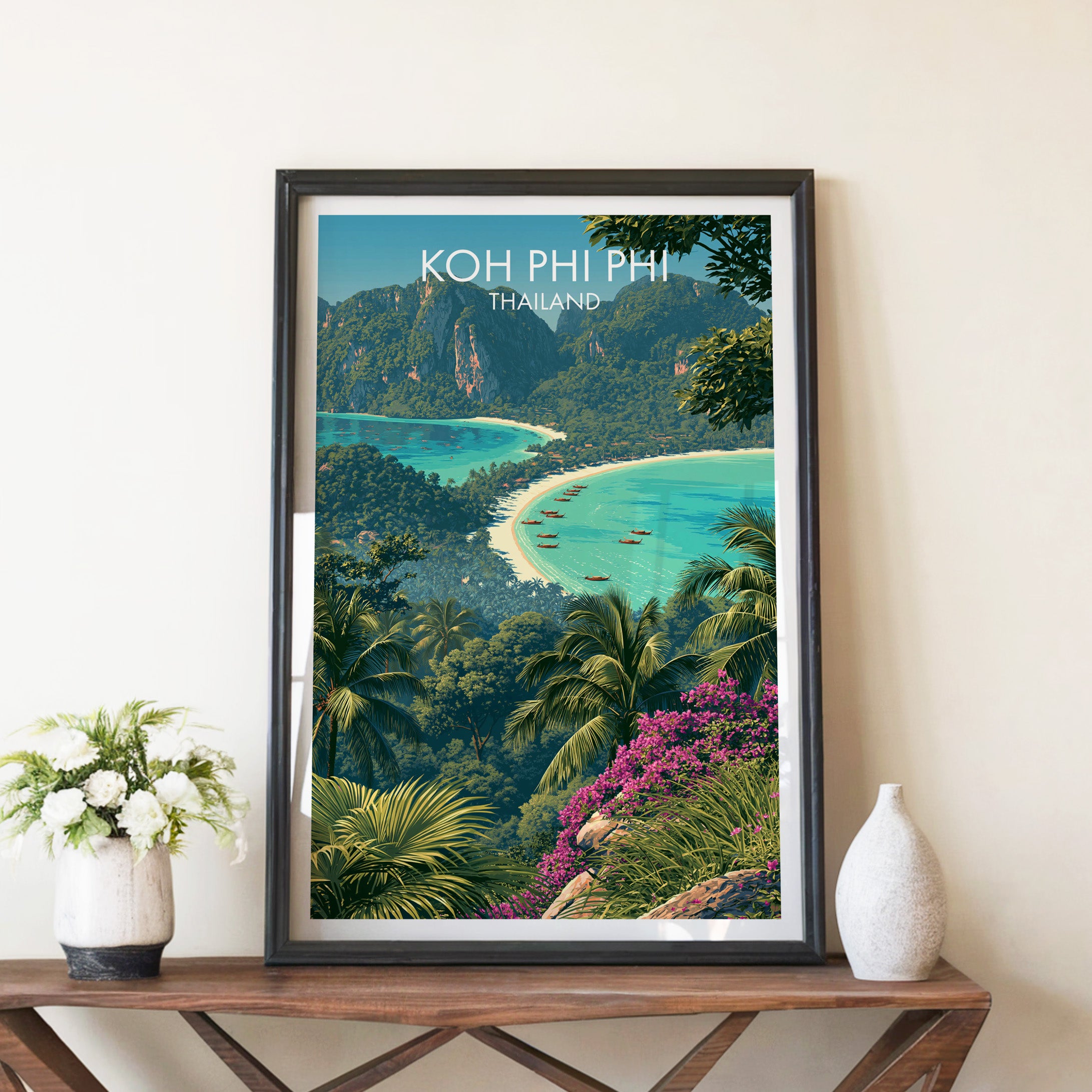 Koh Phi Phi Thailand travel poster in a black frame on a wooden console table with white flowers